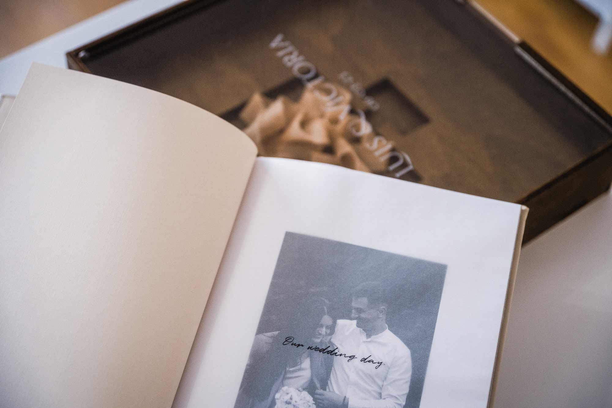 Open wedding photo album next to personalized wooden wedding album box for photographers