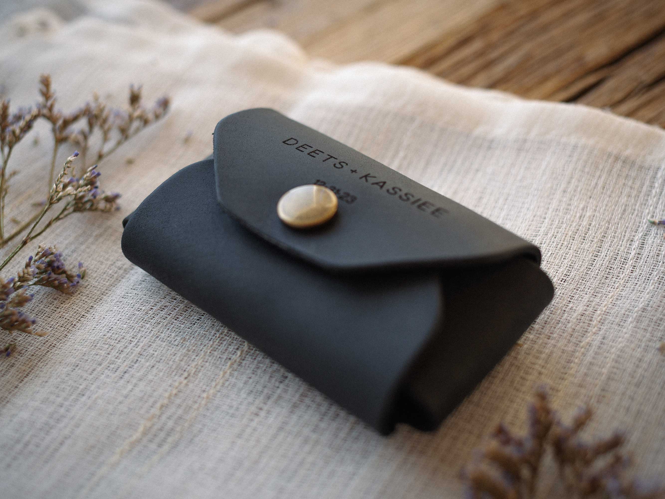 closed black leather usb envelope on linen fabric minimalist packaging