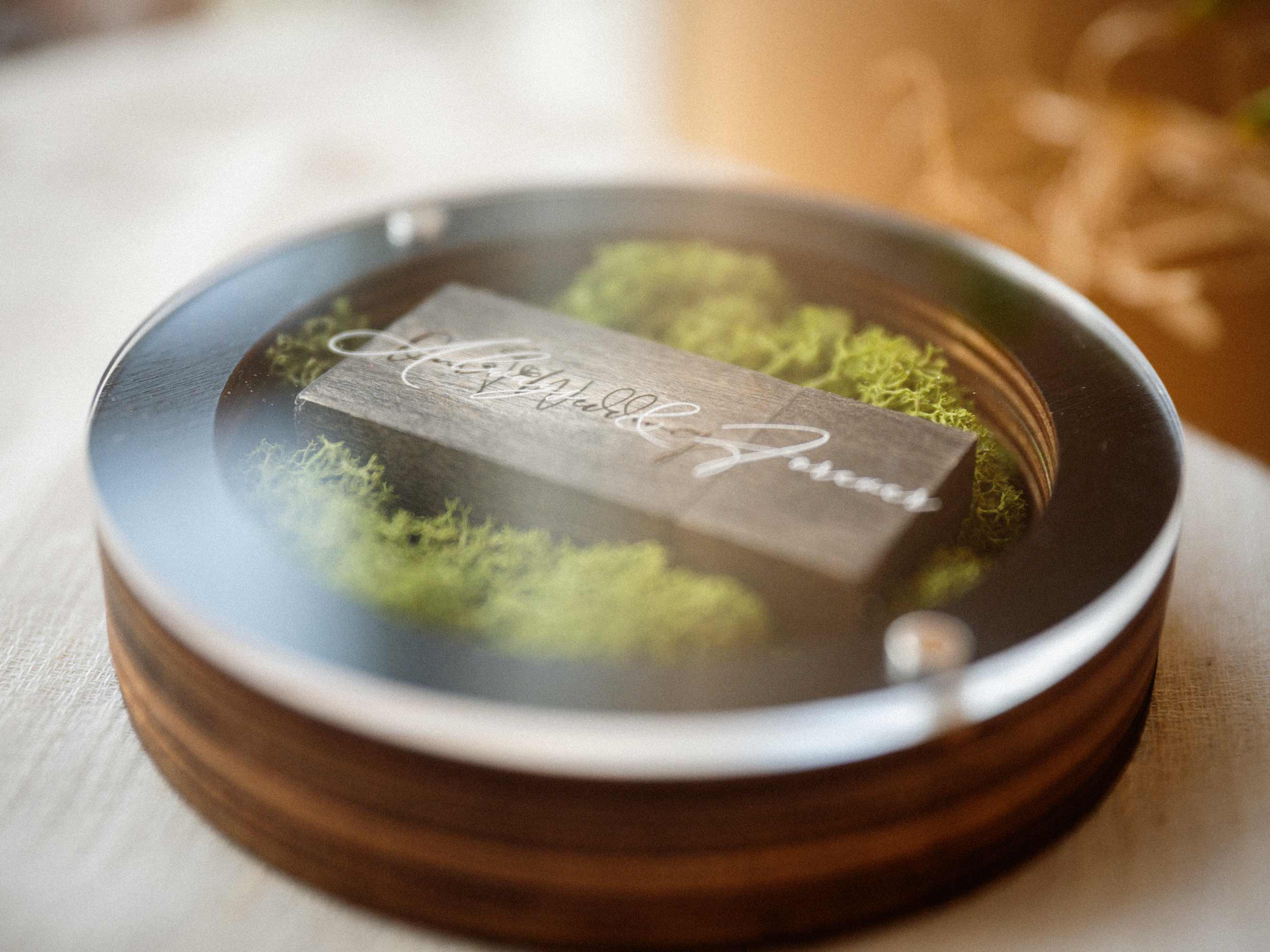Close view of black wedding USB box with wooden flash drive on moss