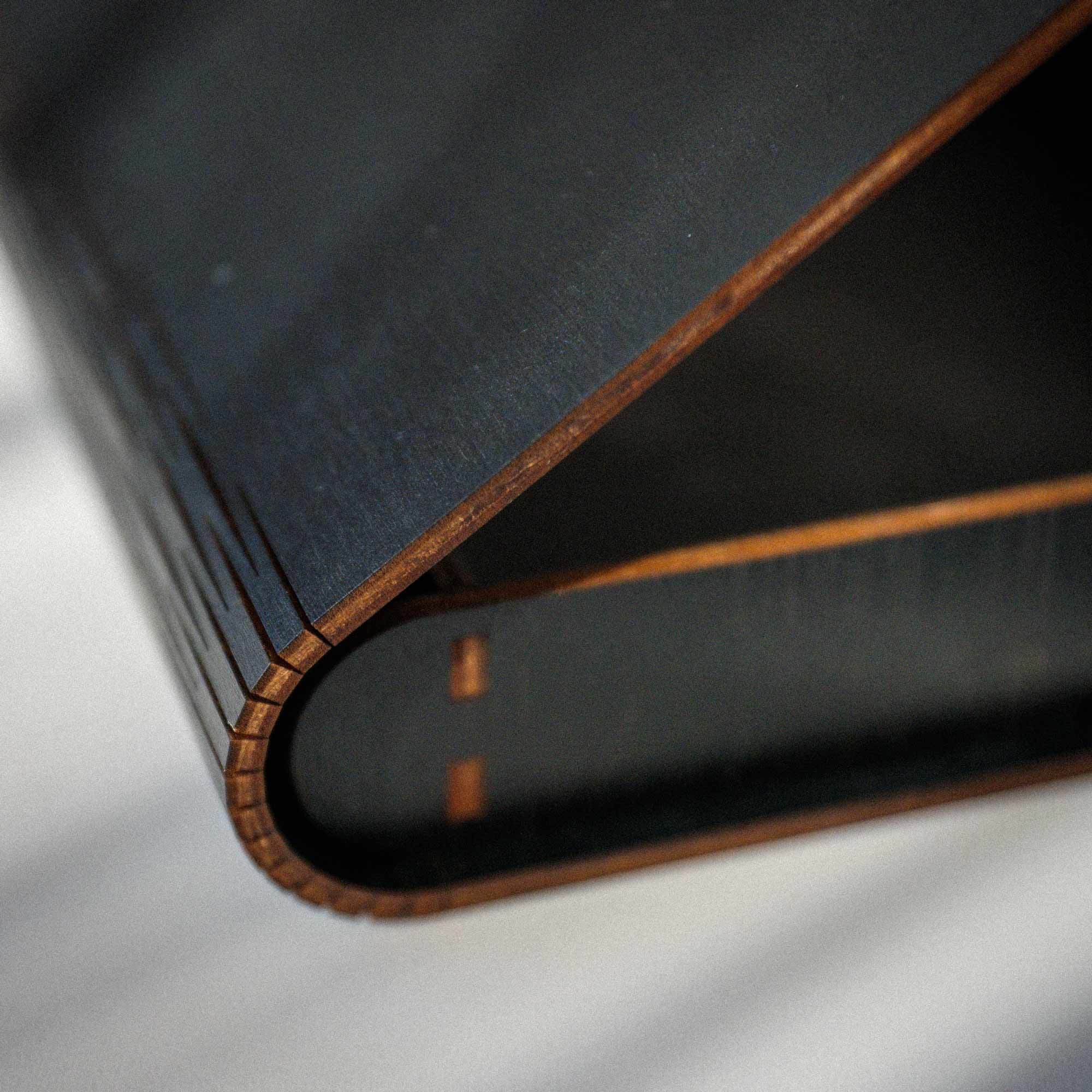 Close-up of black wooden photo box corner and curved handcrafted edge