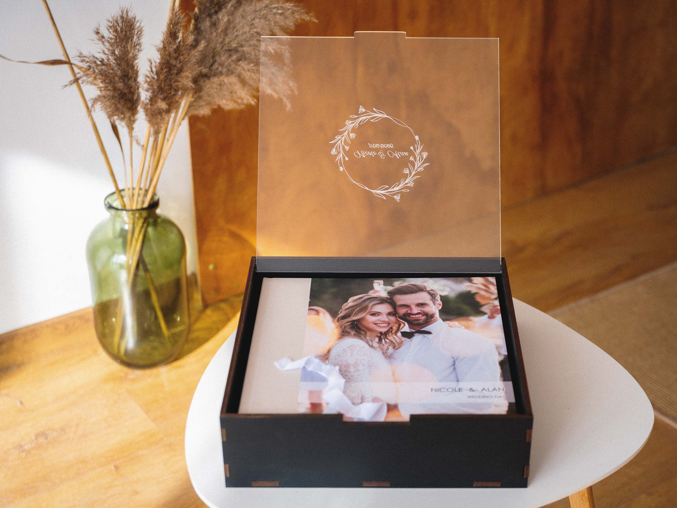 Open black wooden wedding album box with acrylic lid and 12x12 album inside