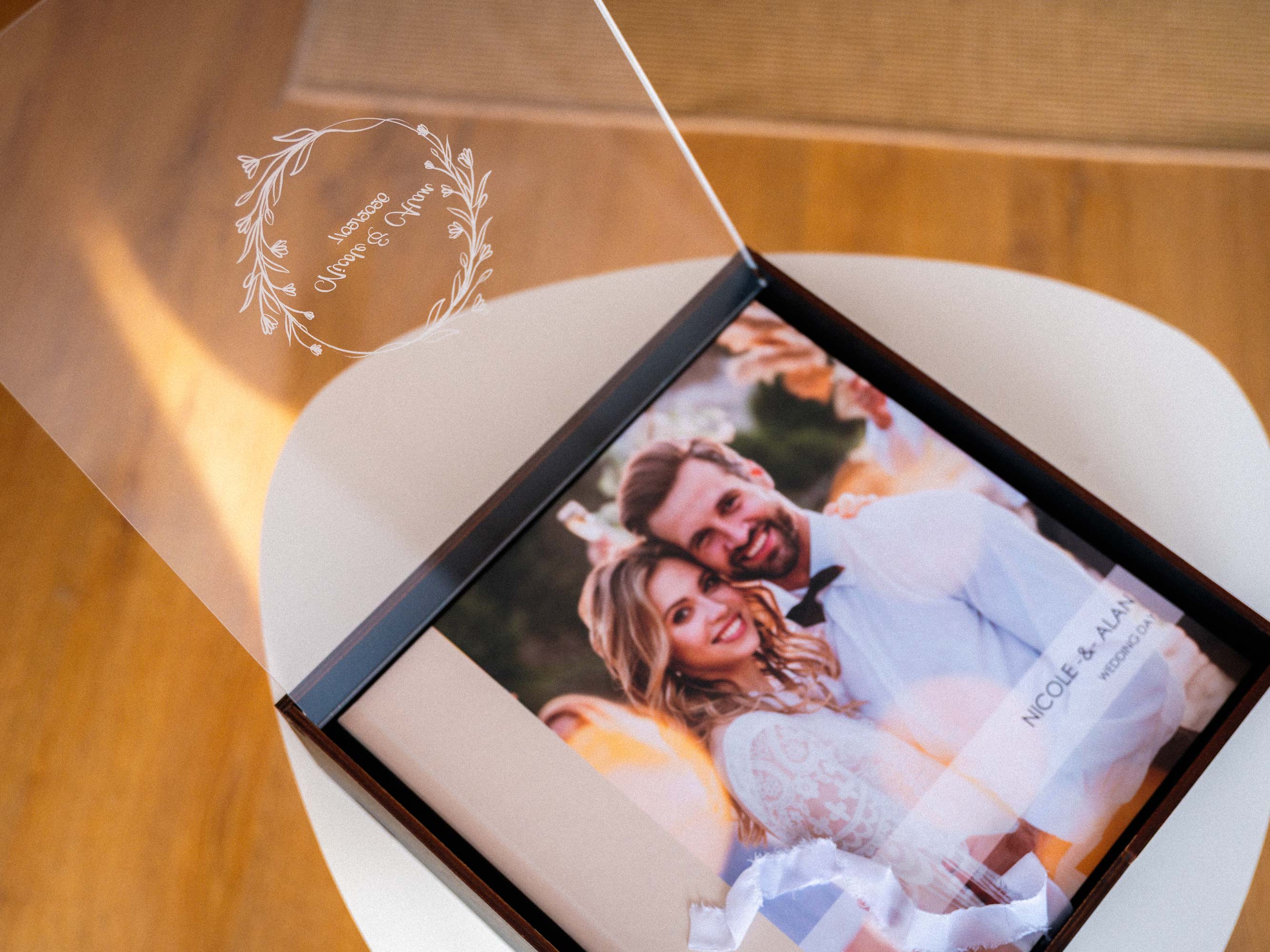 Open black album box with acrylic lid showing wedding photo album