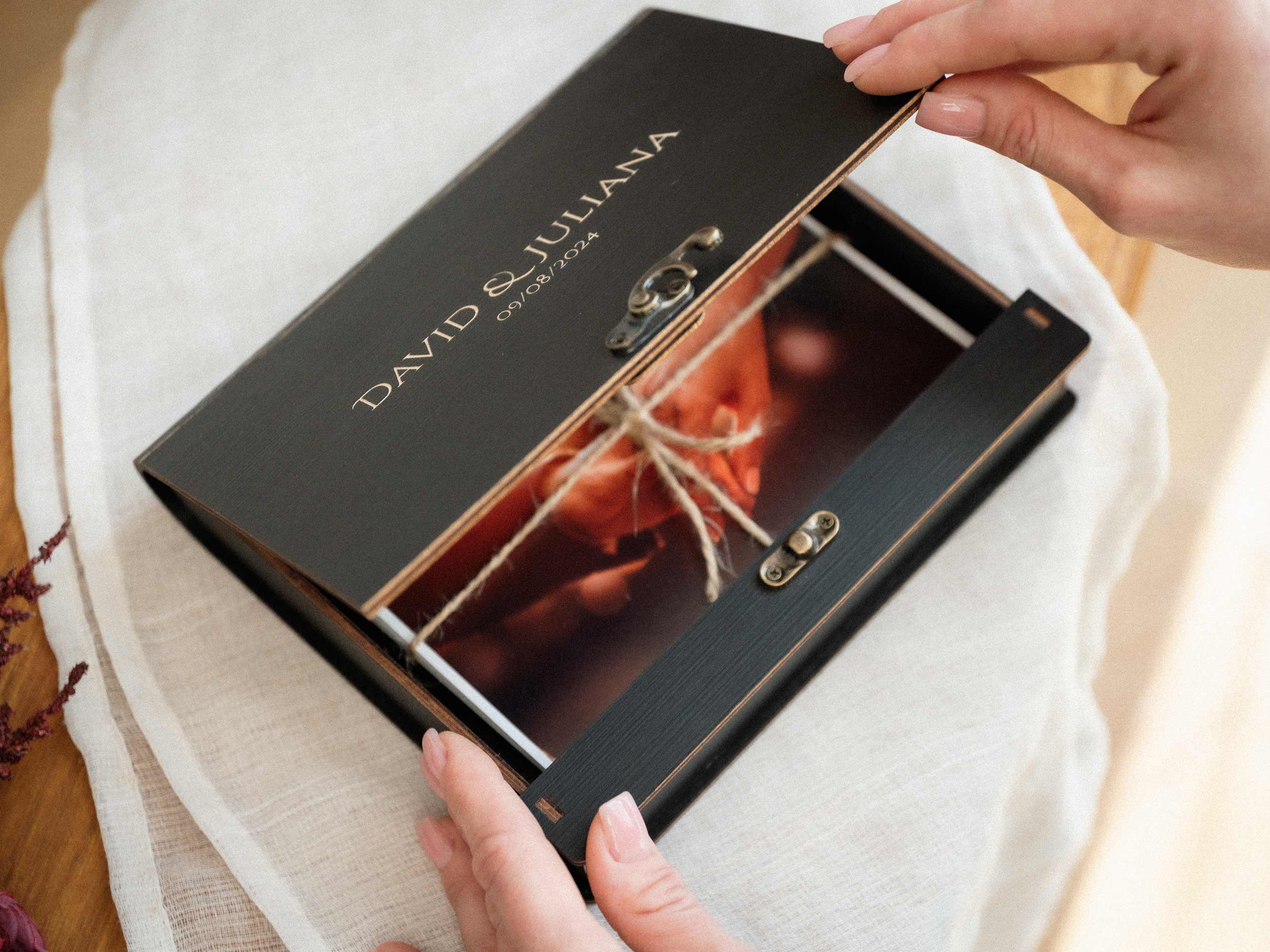 Black wooden wedding photo box with engraved lid and printed photos inside
