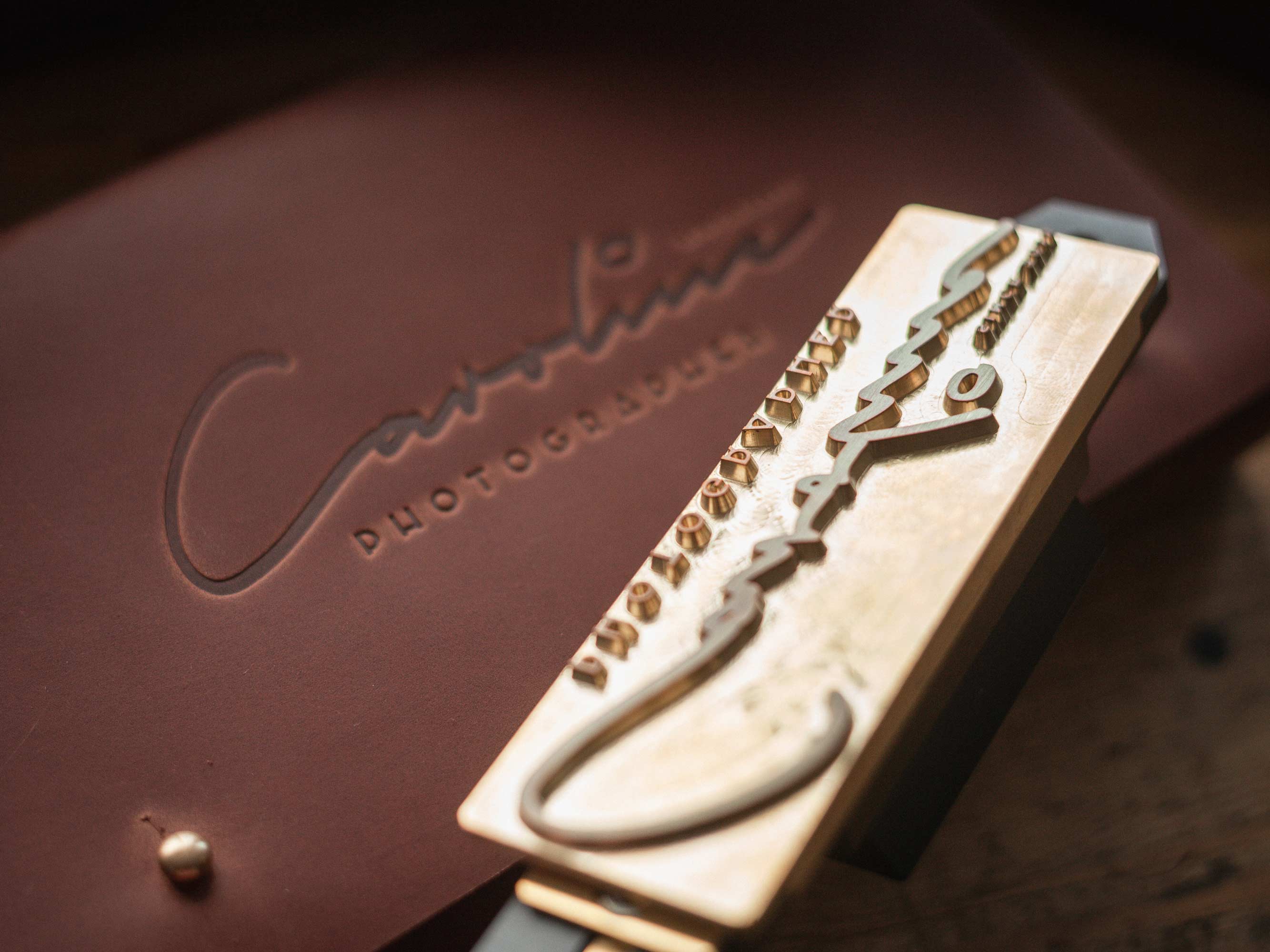 Close-up of brass logo stamp plate creating a clean debossed logo on leather.