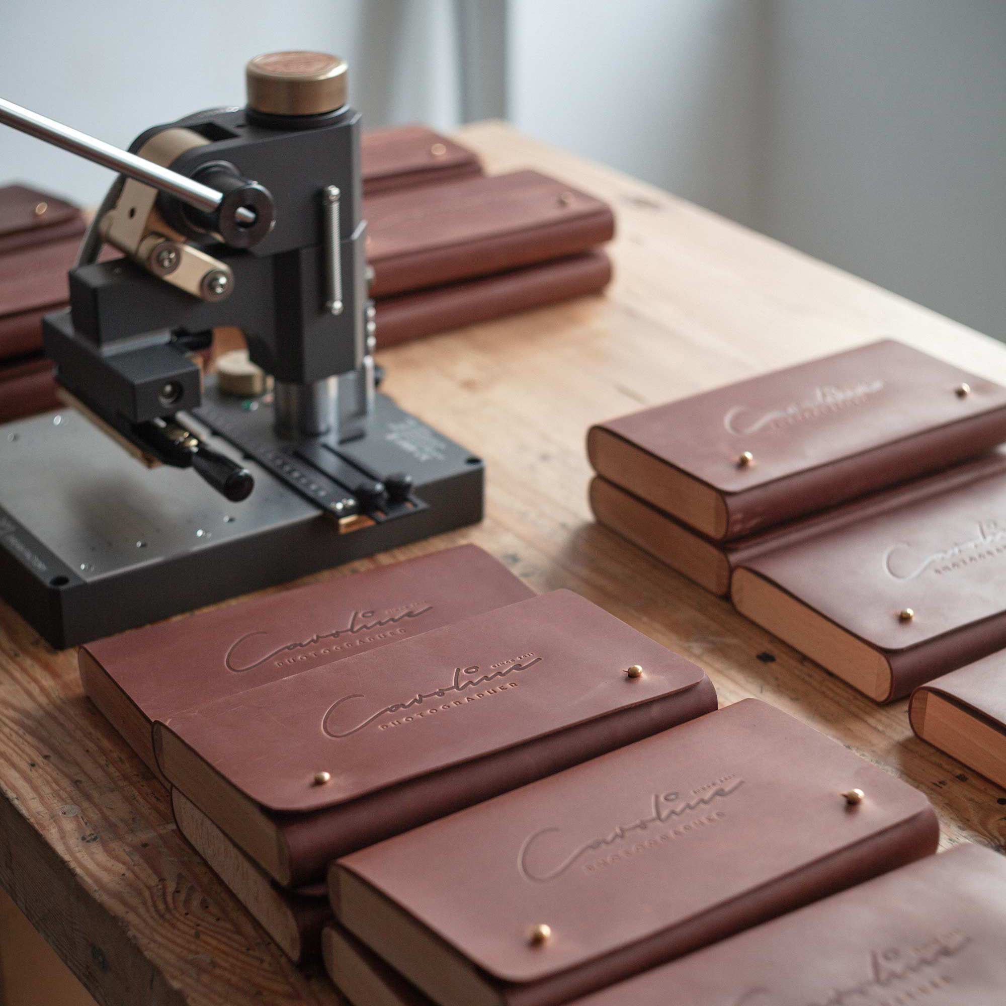 Stack of brown leather envelopes with custom debossed photographer logo.