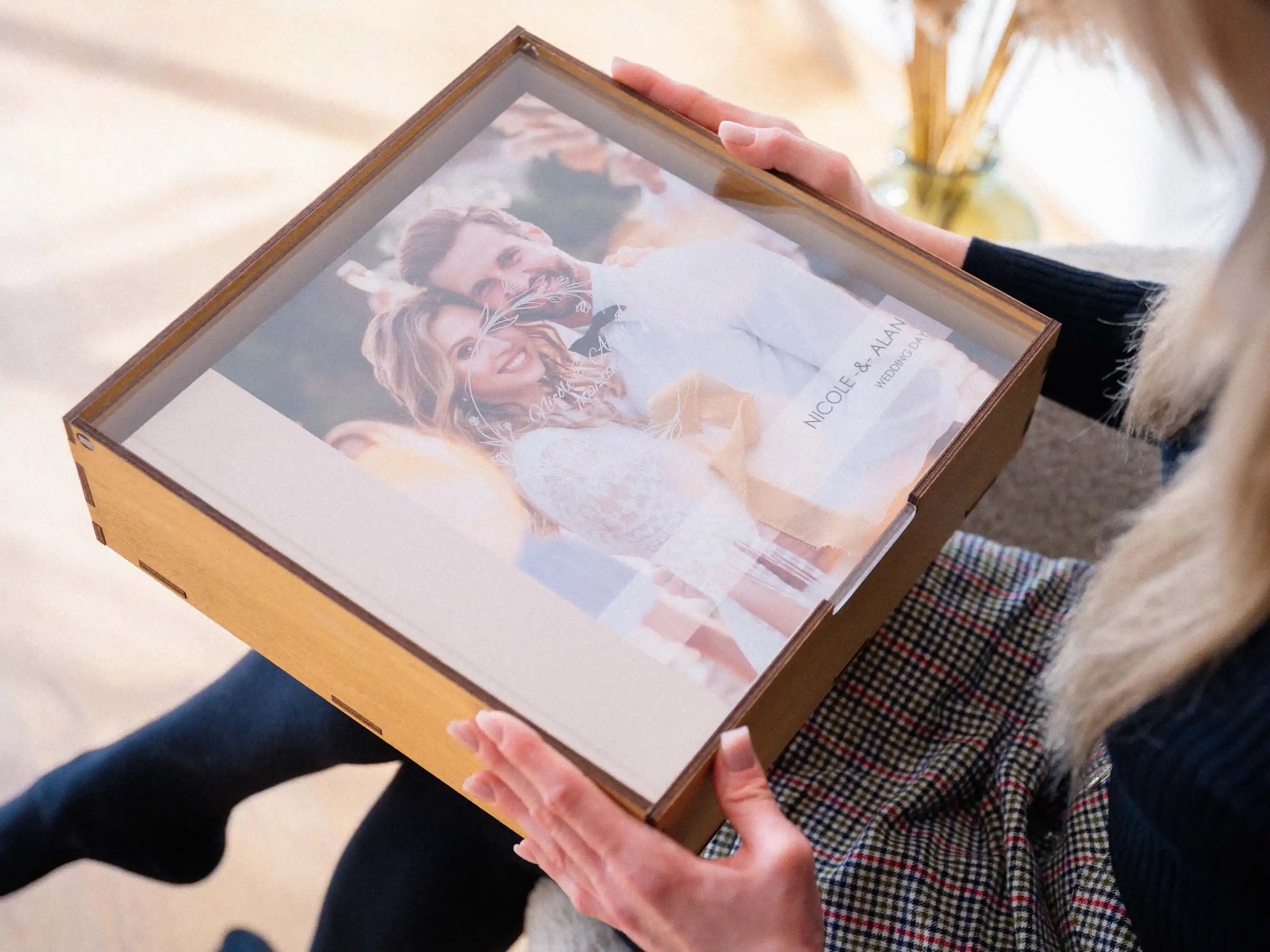 Gold Oak acrylic lid wedding album box held in hands with album visible through the lid