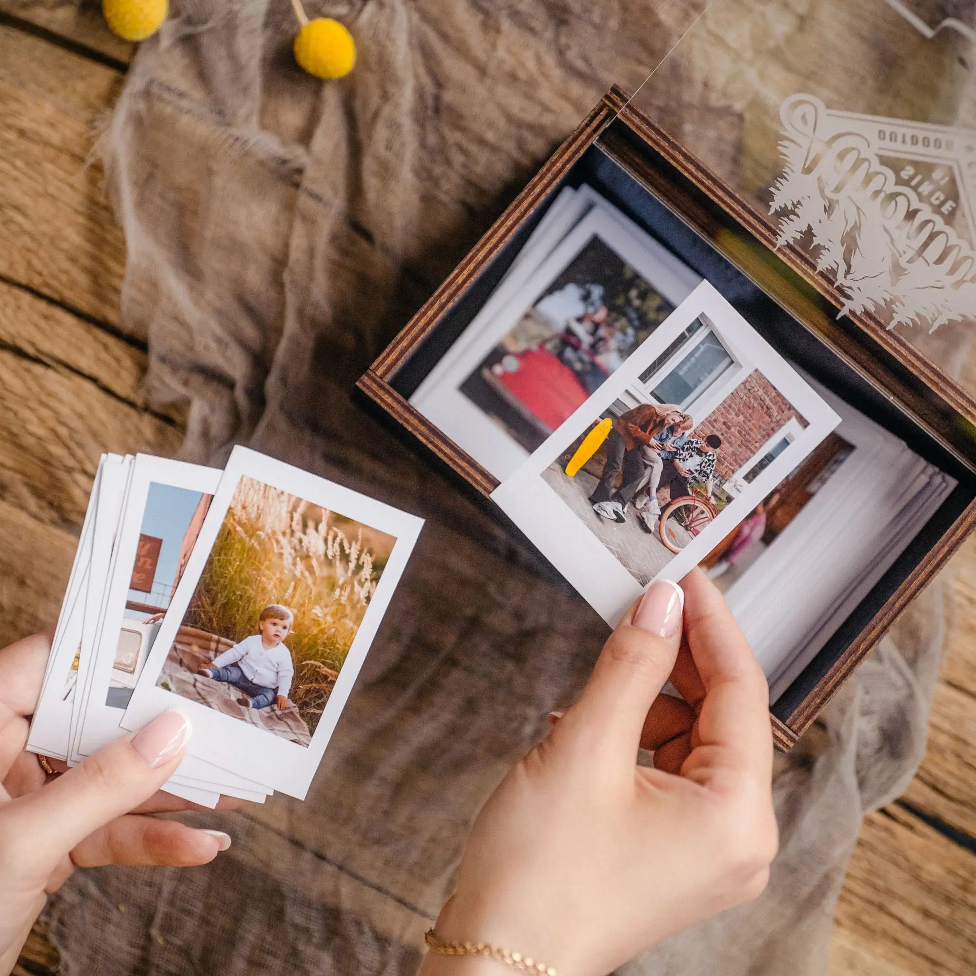 Hand holding an Instax Mini print above a black personalized photo box