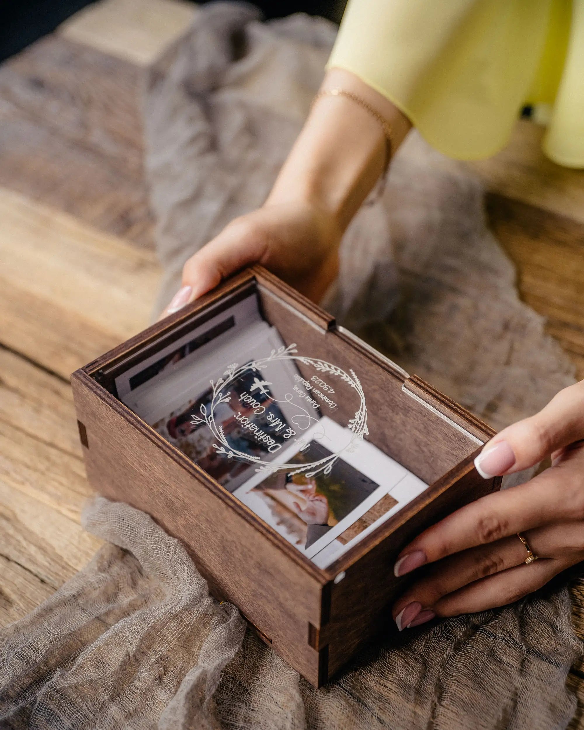 Hands holding a personalized wooden Instax Mini photo box