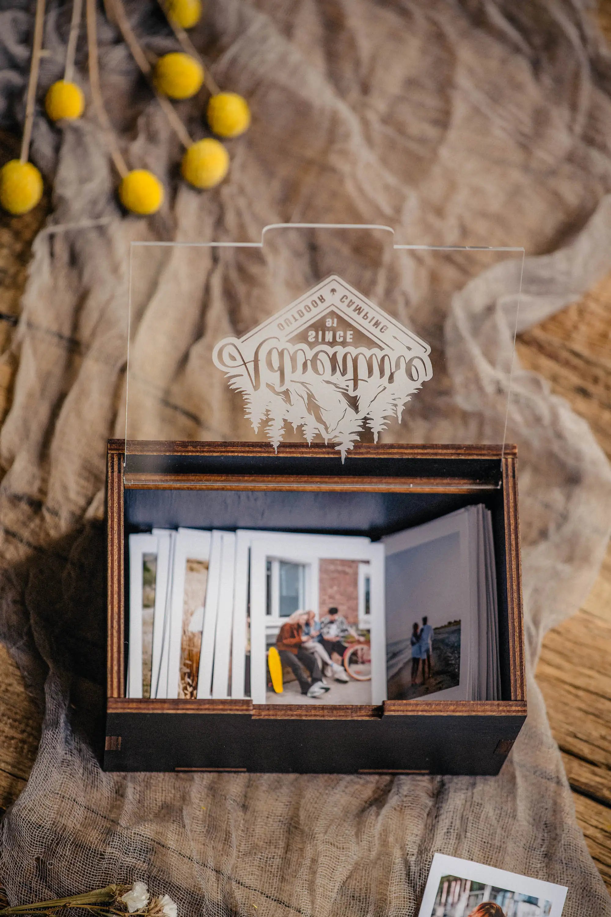 Black Instax Mini photo storage box with instant prints on rustic background