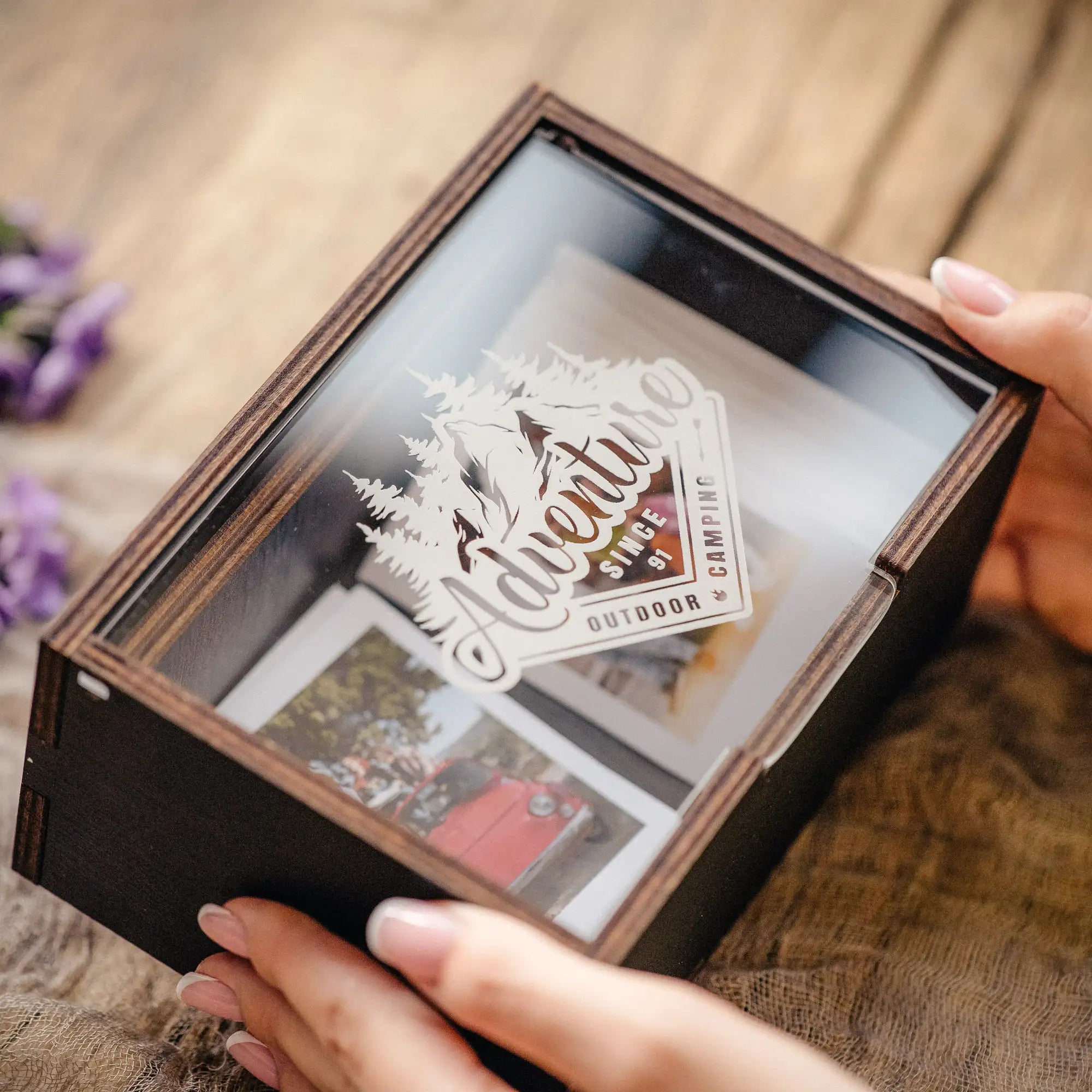 Close-up of a personalized Instax Mini photo box with acrylic lid and prints