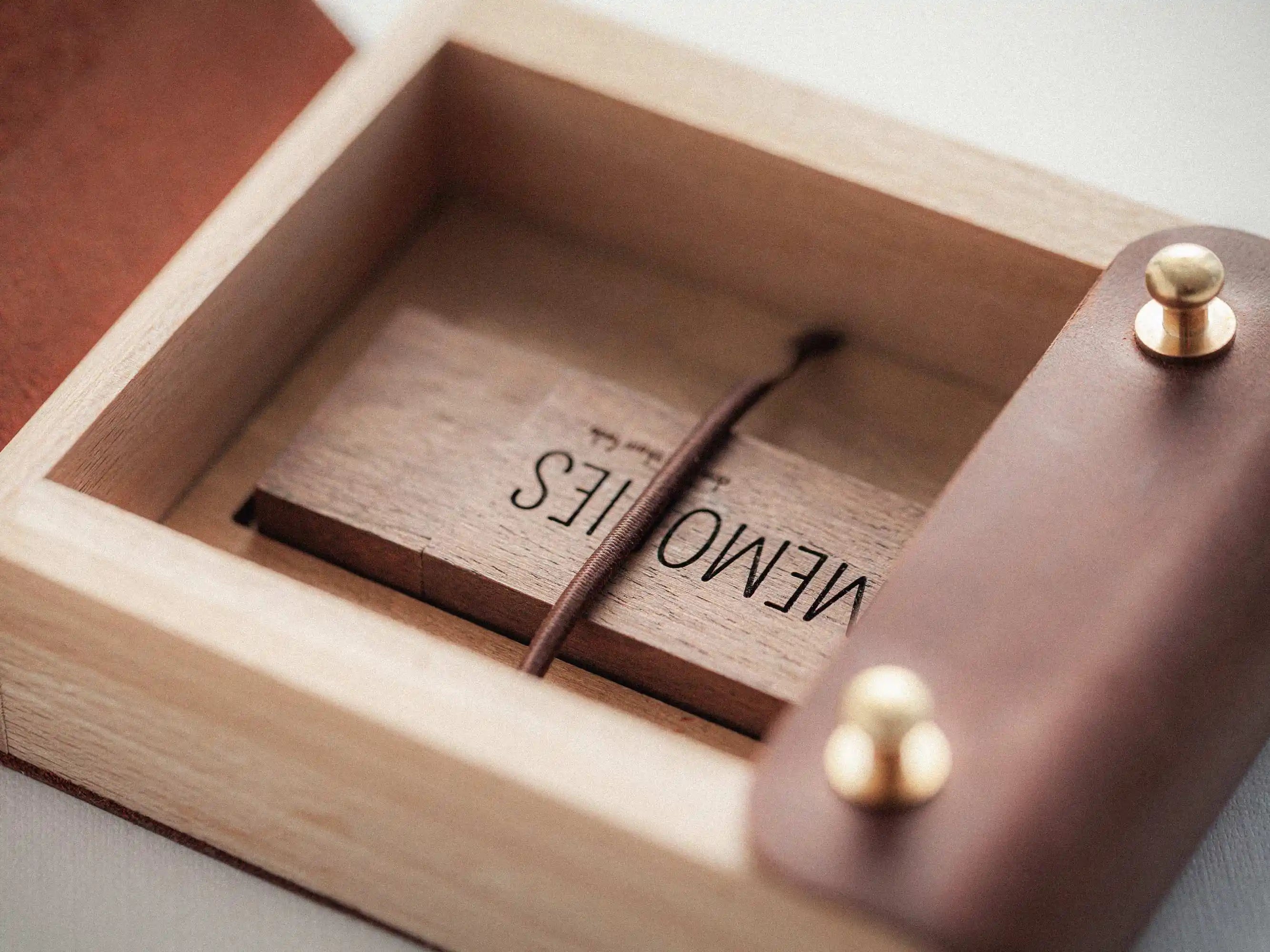 Close-up open box corner with wooden USB drive inside, secure elastic holder