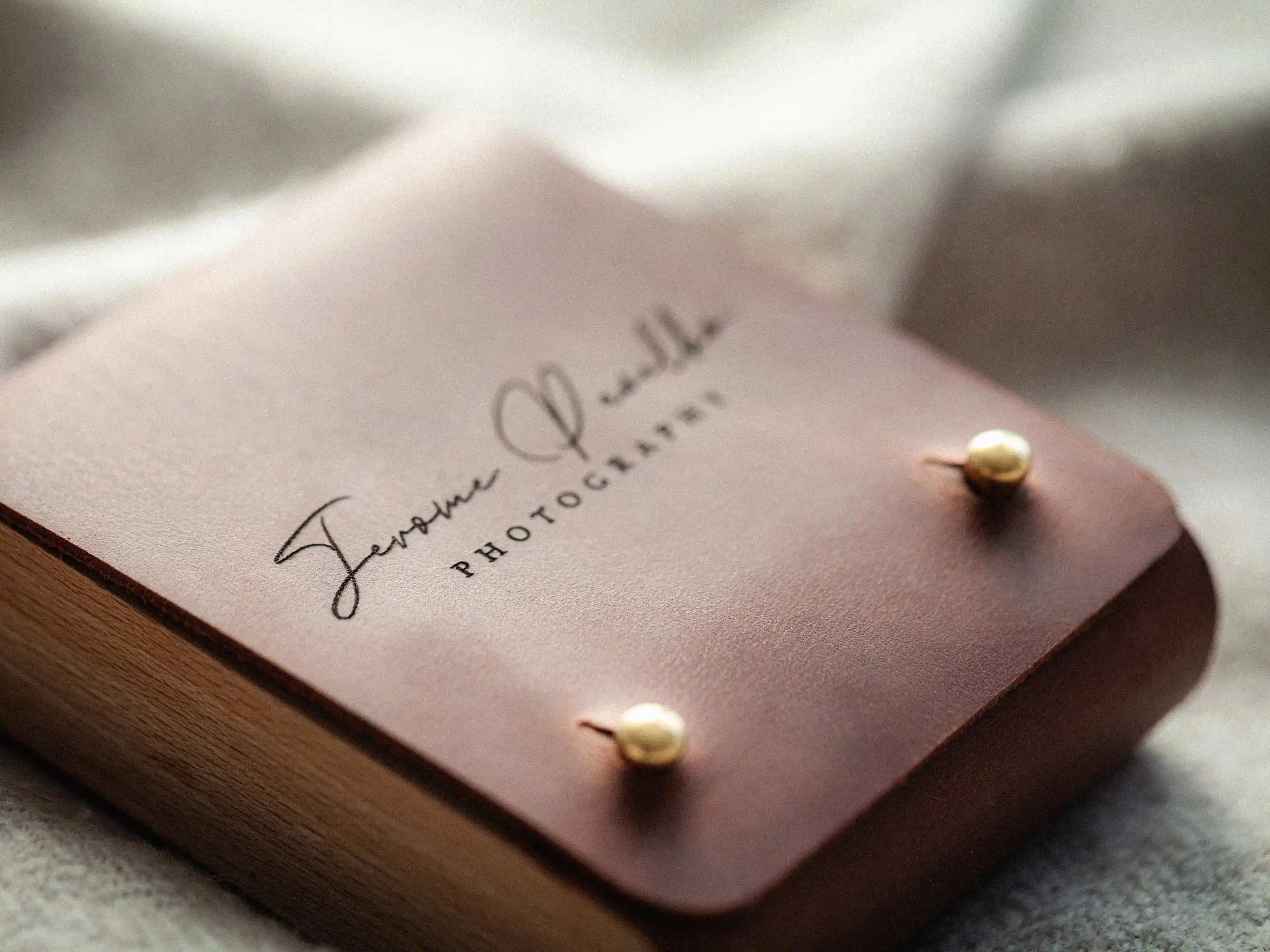 Close-up of engraved logo on cognac leather USB box lid with brass studs