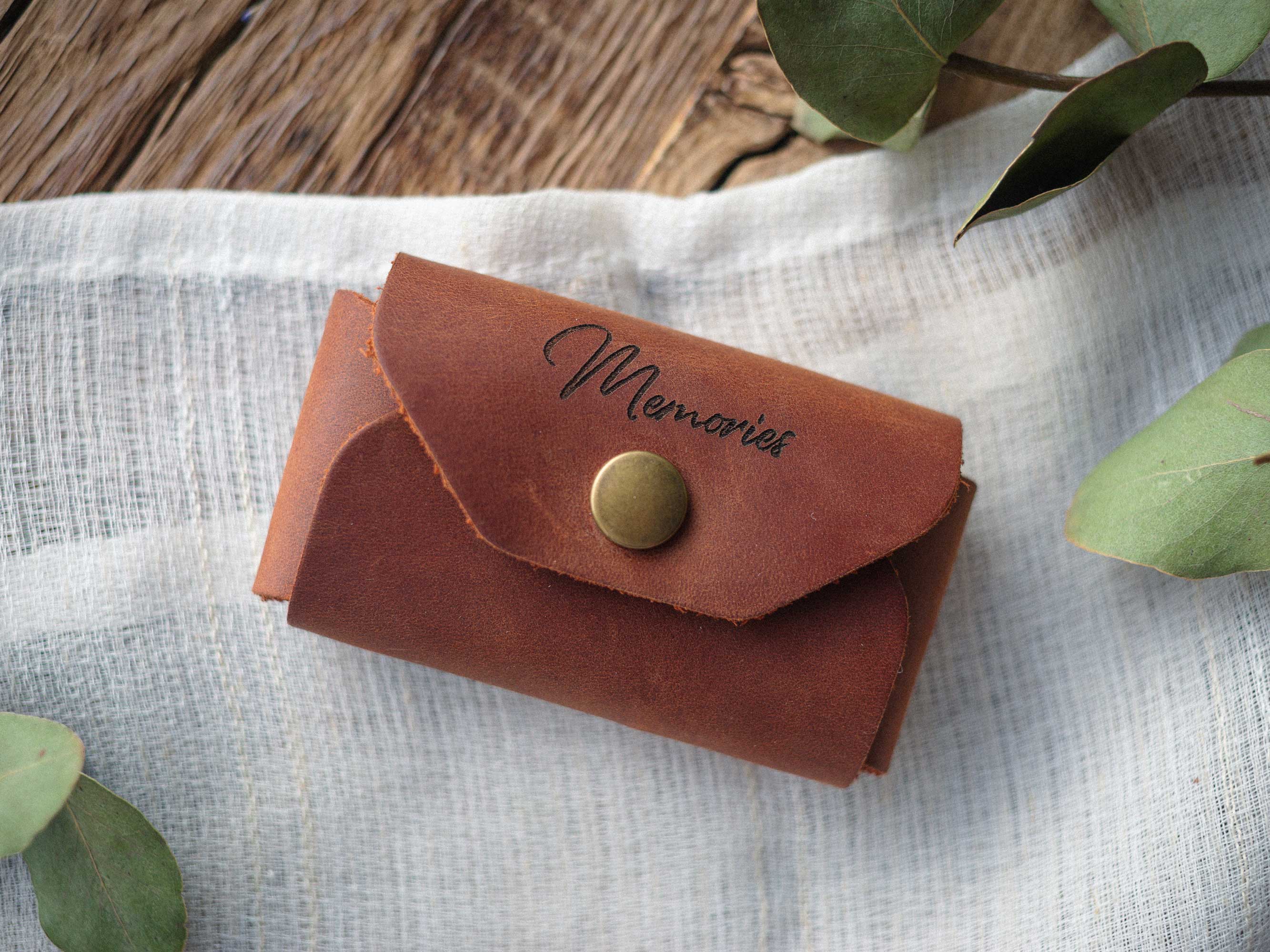 Closed cognac Crazy Horse leather USB envelope with Memories engraving on light fabric