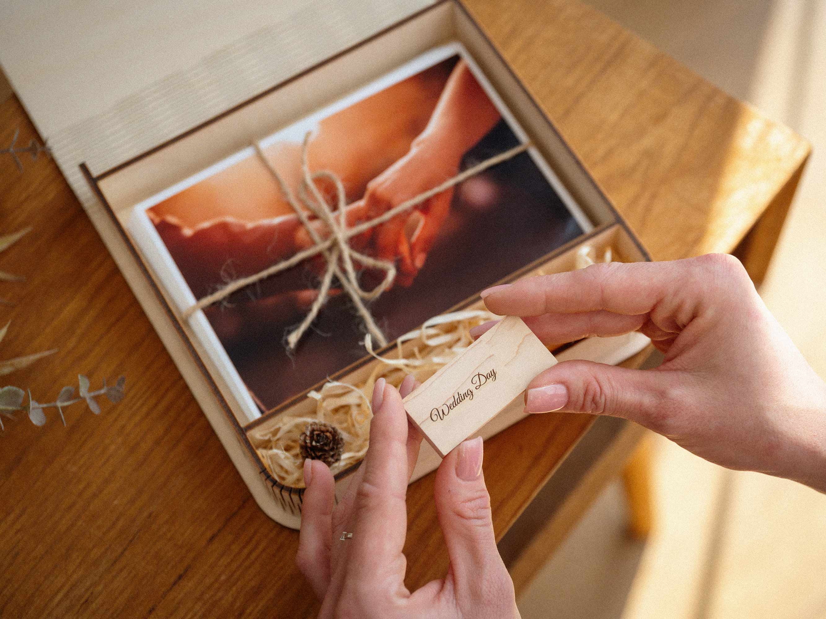 Maple wedding photo box with USB and engraved wooden flash drive in hands