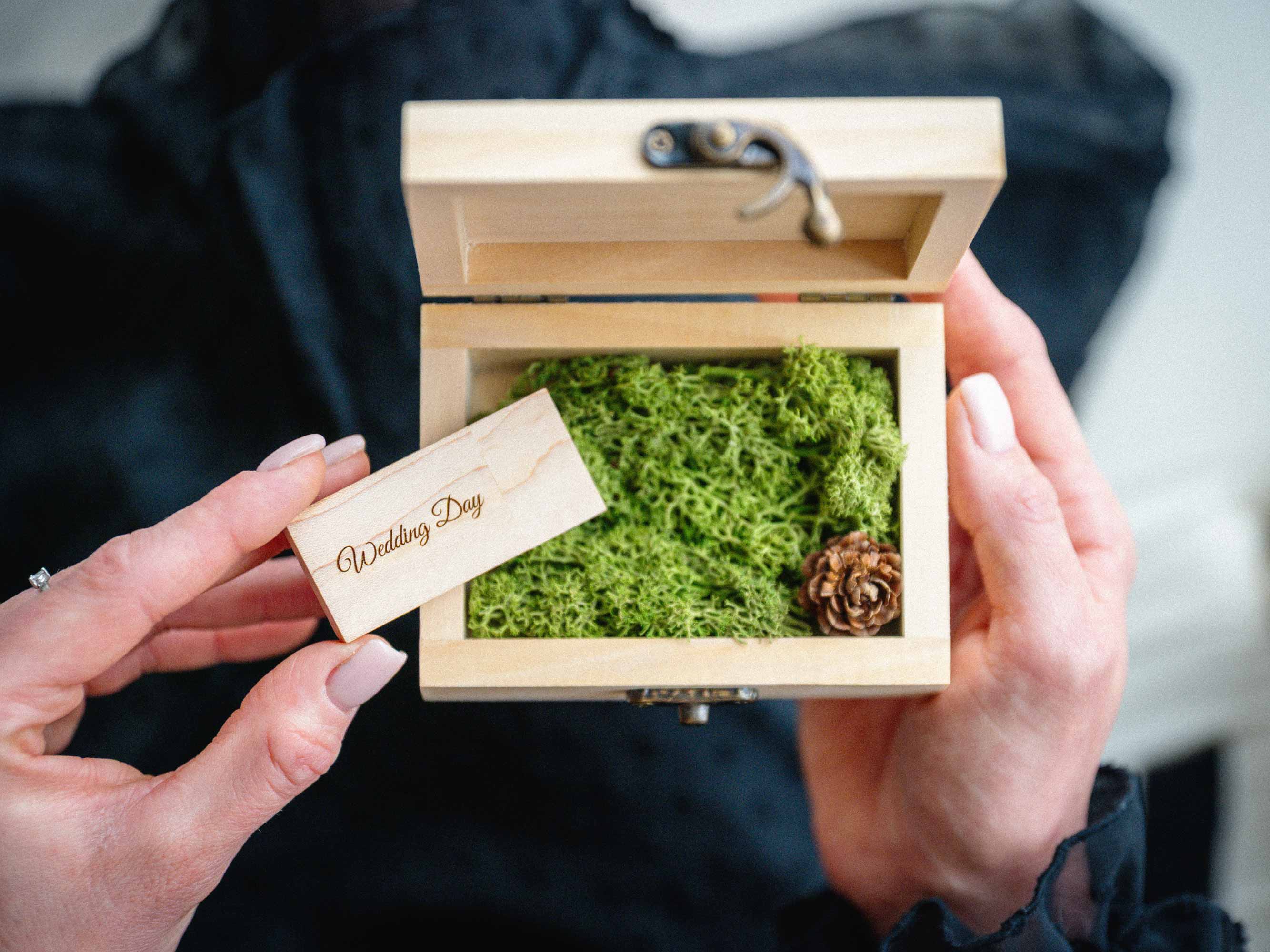 Natural wooden USB box with flash drive and moss held in hands