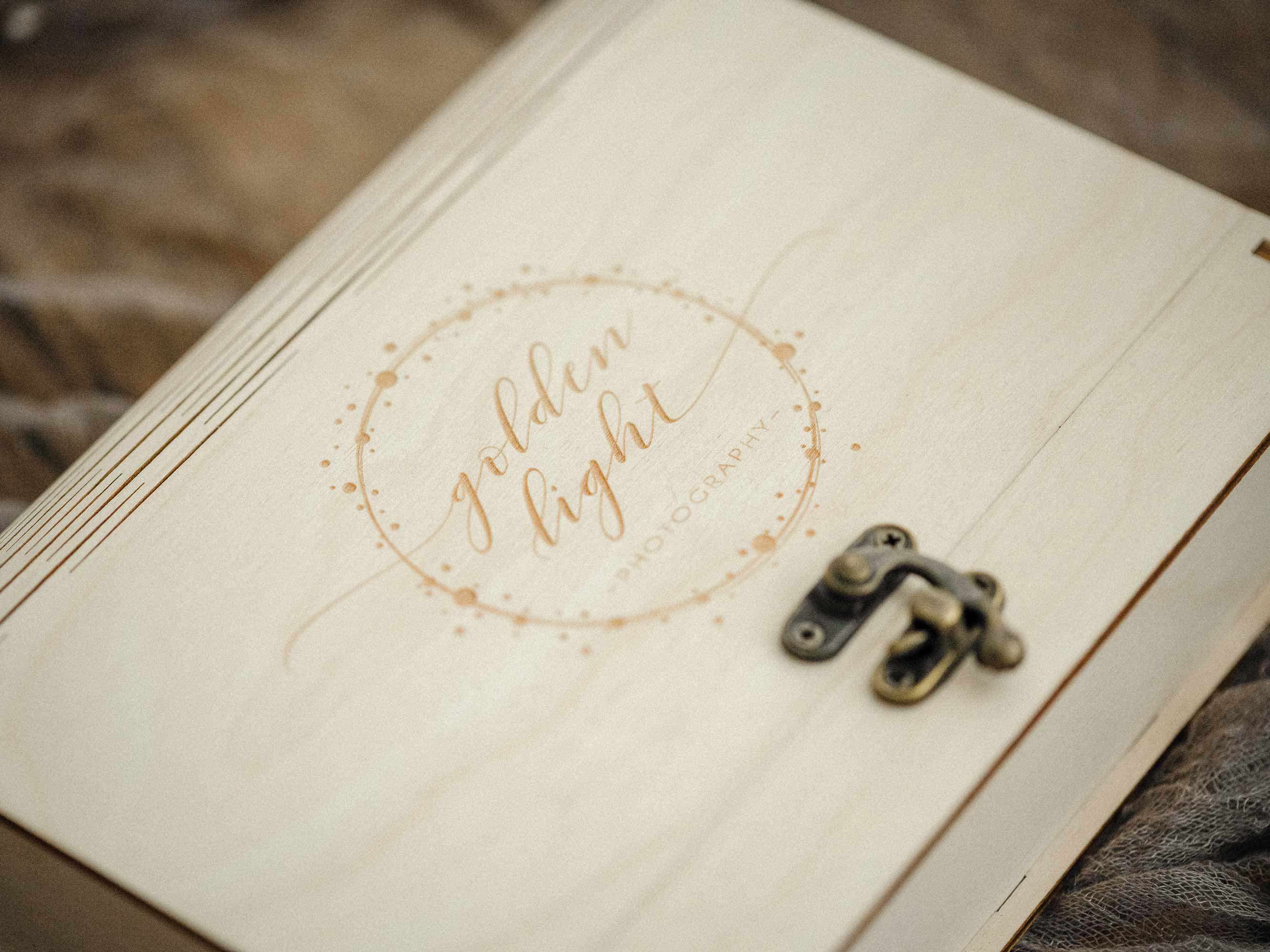 Close-up of engraved lid and vintage metal hook on a maple wedding photo box