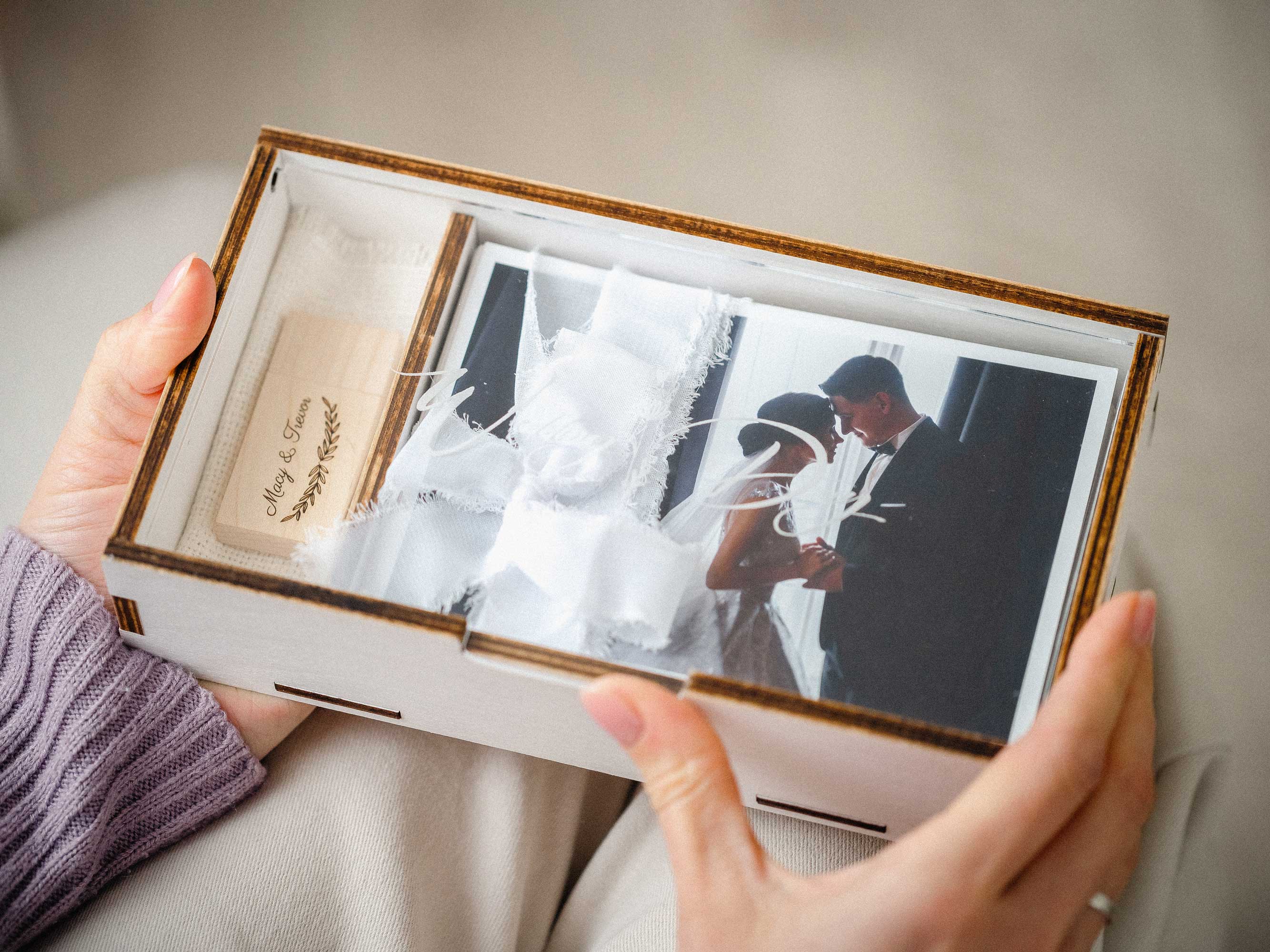 White wooden photo box with USB and wedding print held in hands