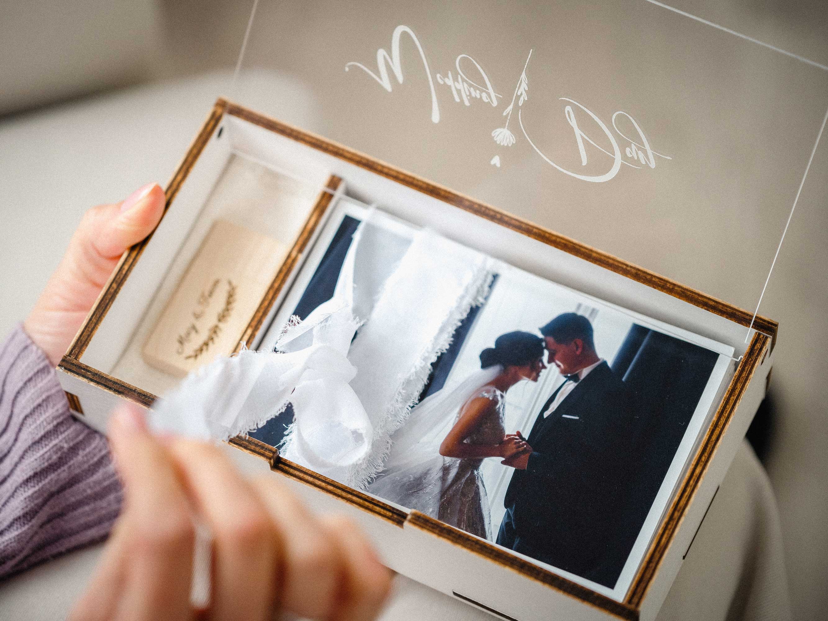 White wedding photo box with wooden USB and printed wedding photo in hands
