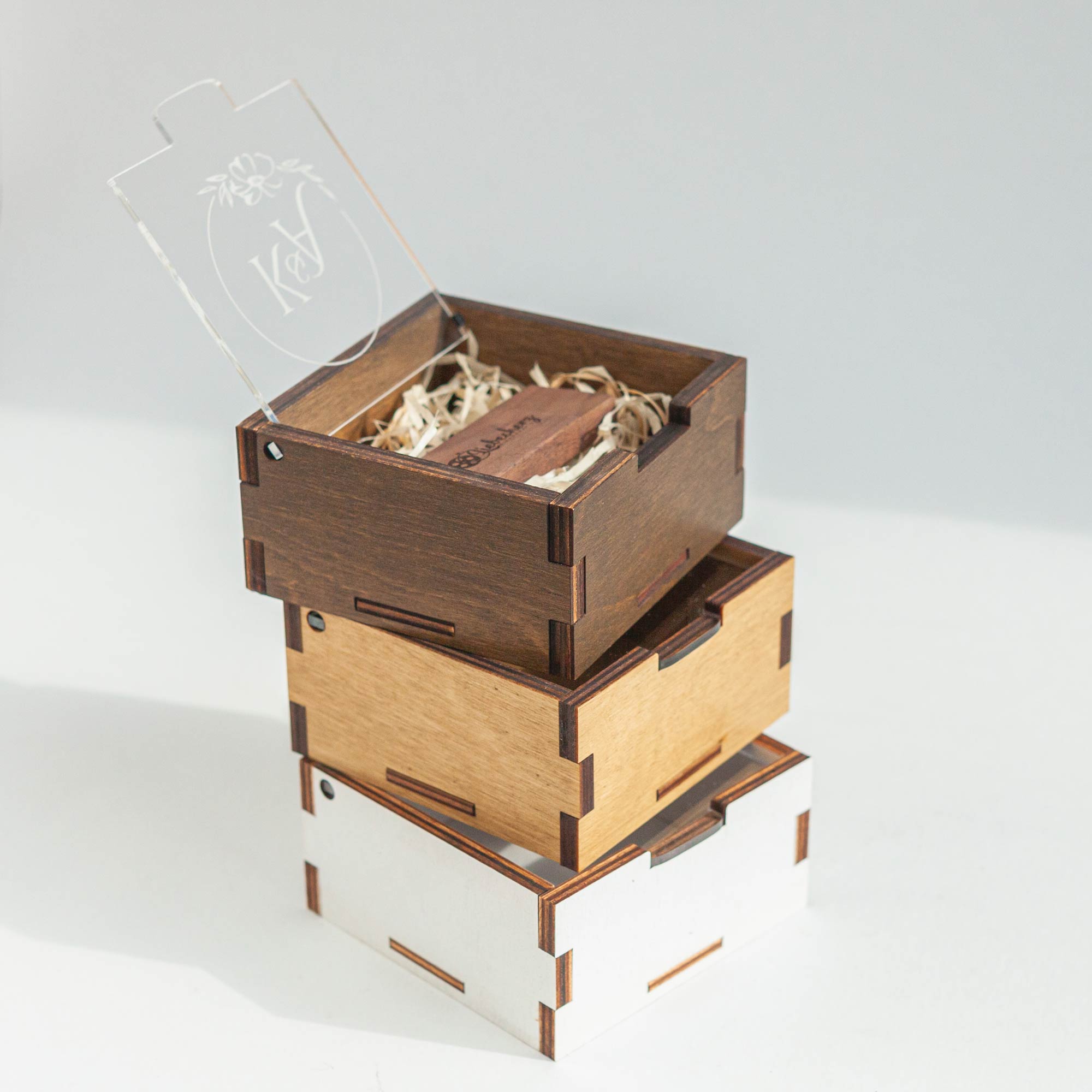 Stacked wooden USB boxes with engraved acrylic lids
