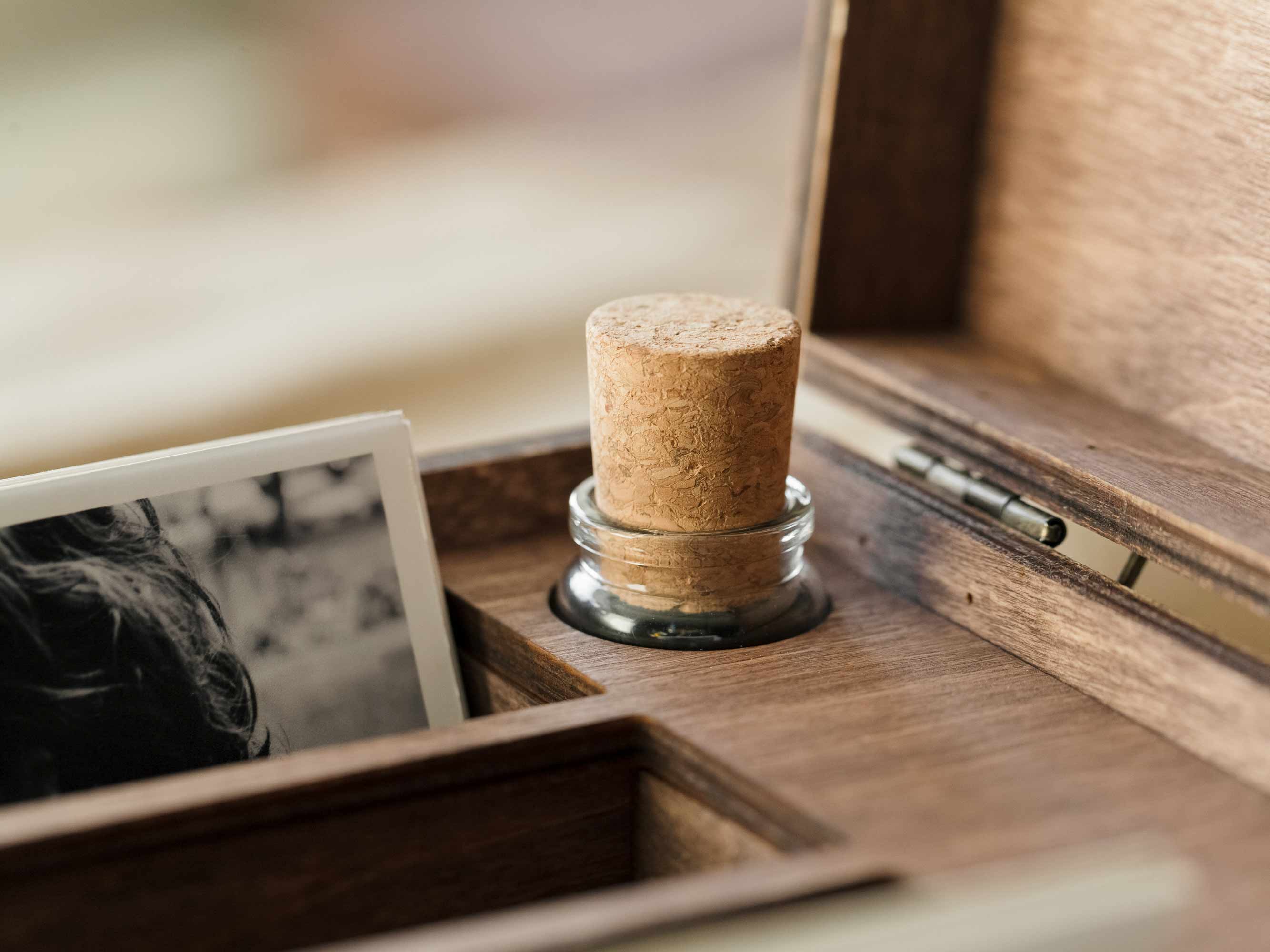 Close-up of cork stopper and USB slot inside wooden family photo box