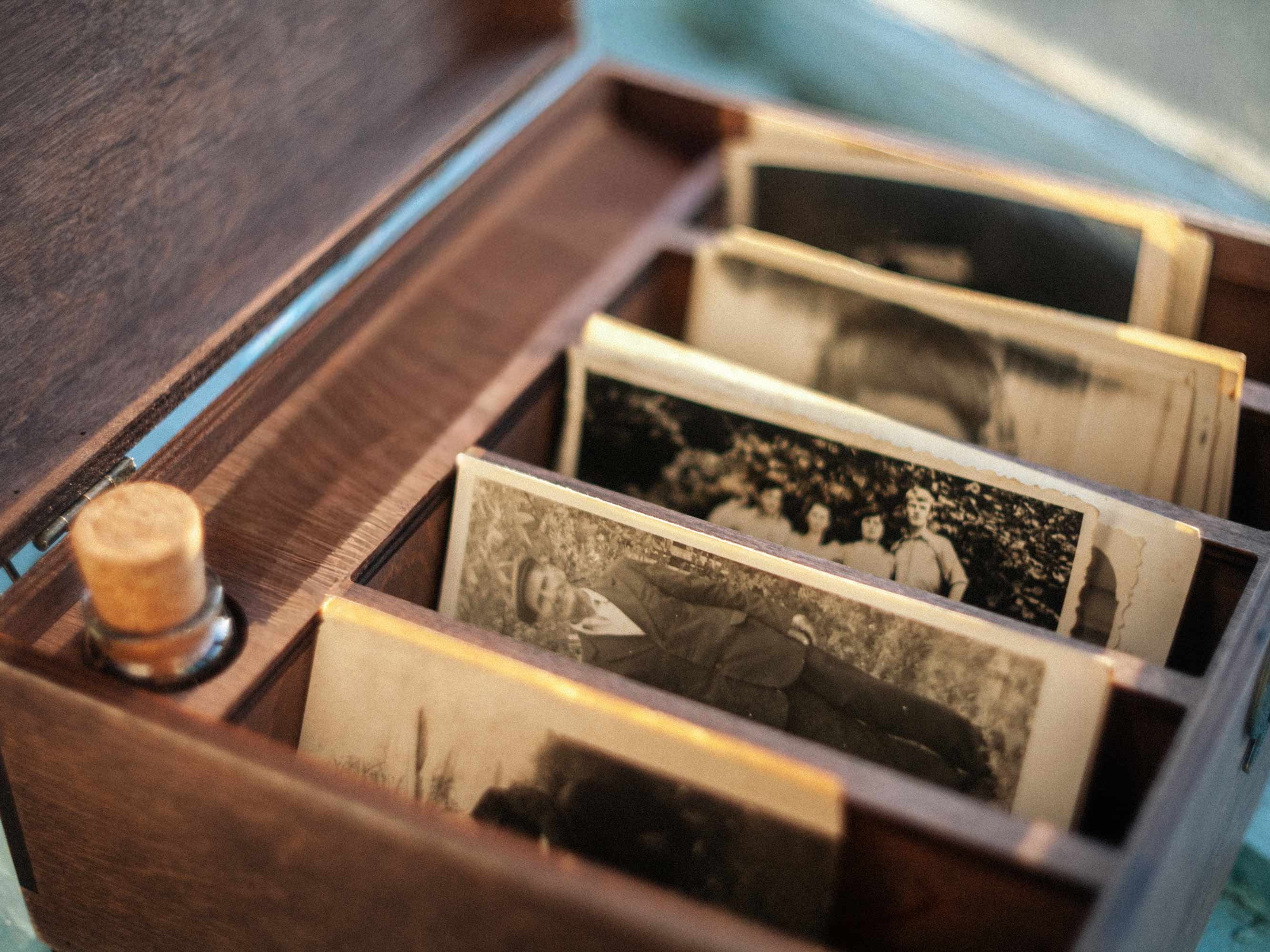 Interior of family photo box with vintage photos arranged in five sections