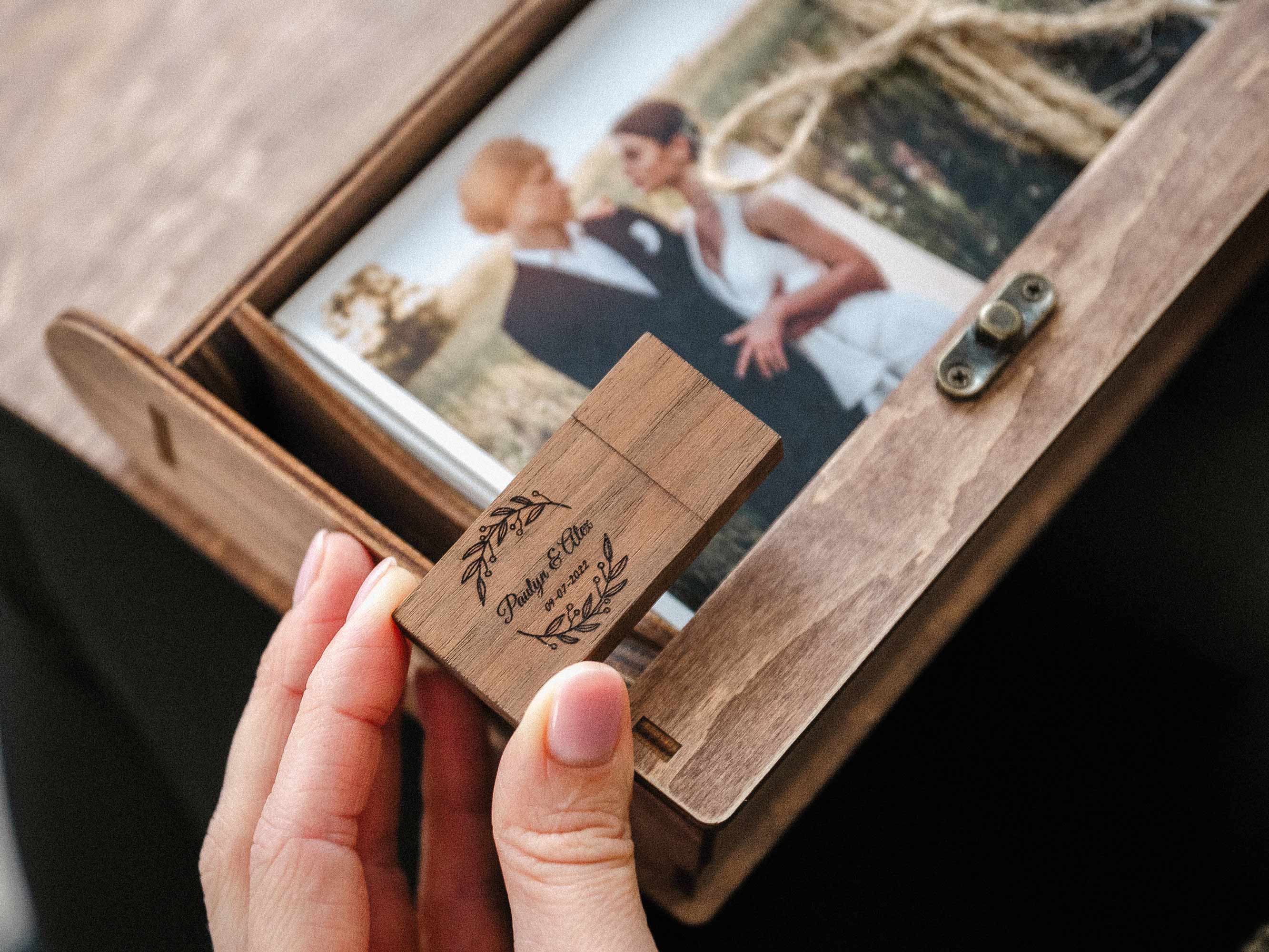 Close-up of walnut photo box interior with wedding prints and wooden USB in dedicated compartment