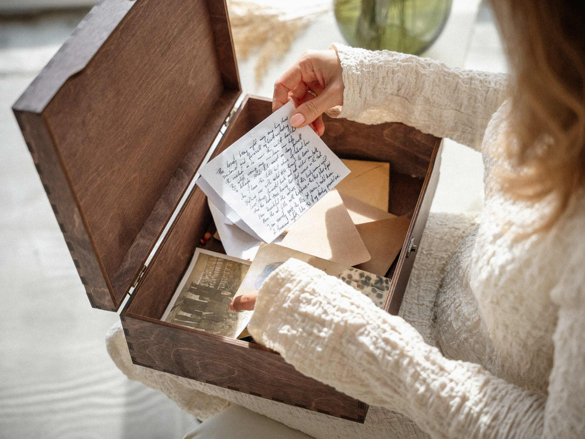 Open wedding memory box storing letters, photos and jewelry