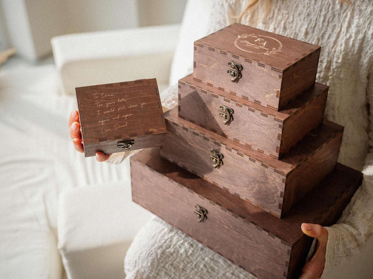 Woman holding stacked wooden wedding keepsake boxes