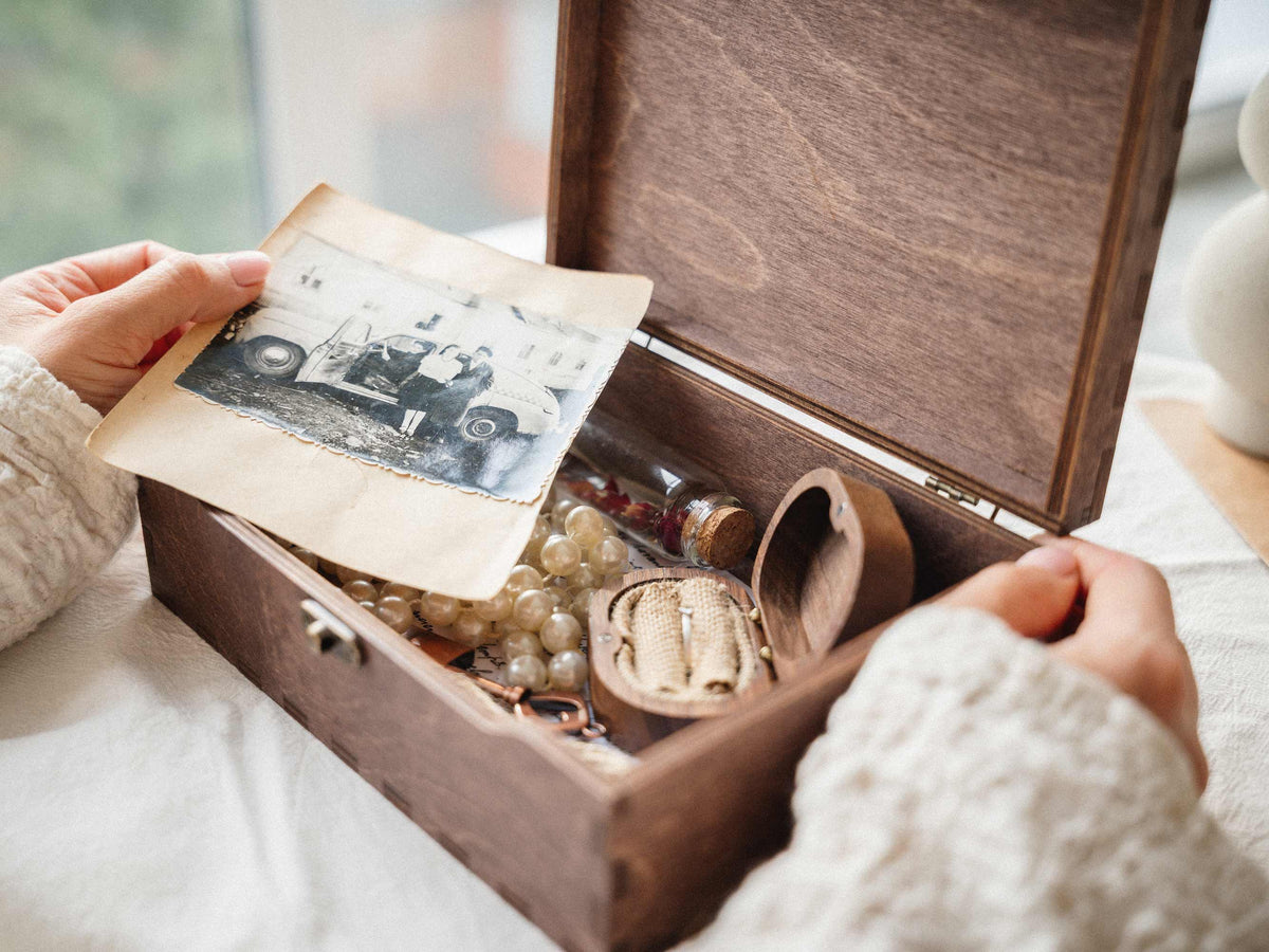 Open wooden memory box with wedding photographs and keepsakes