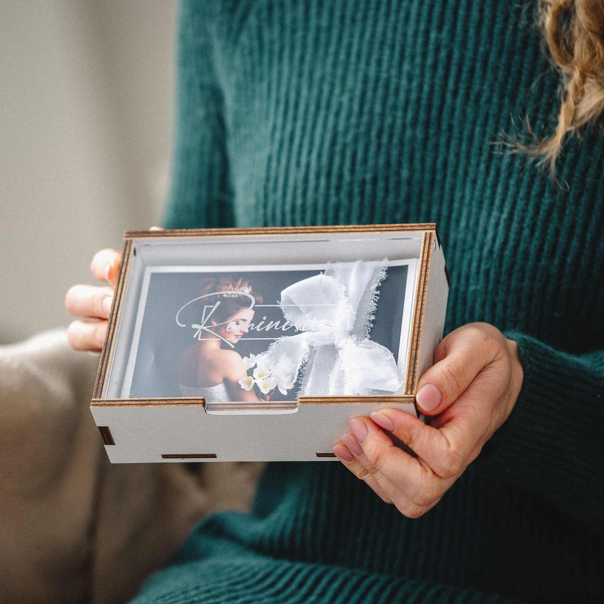 Detail of custom engraving on acrylic lid of white wooden photo box.