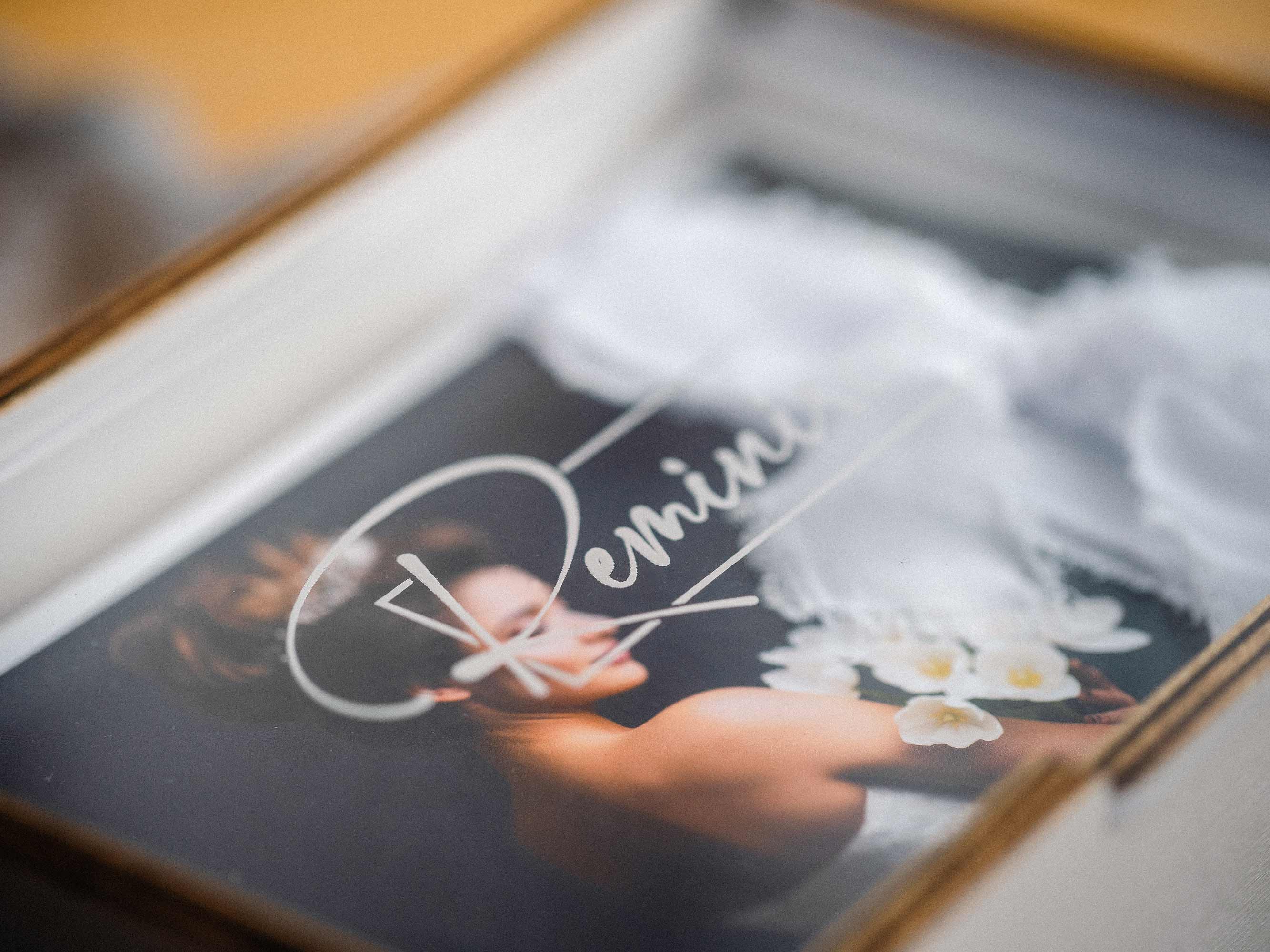 Opening acrylic lid with custom names engraving on white wooden print box.