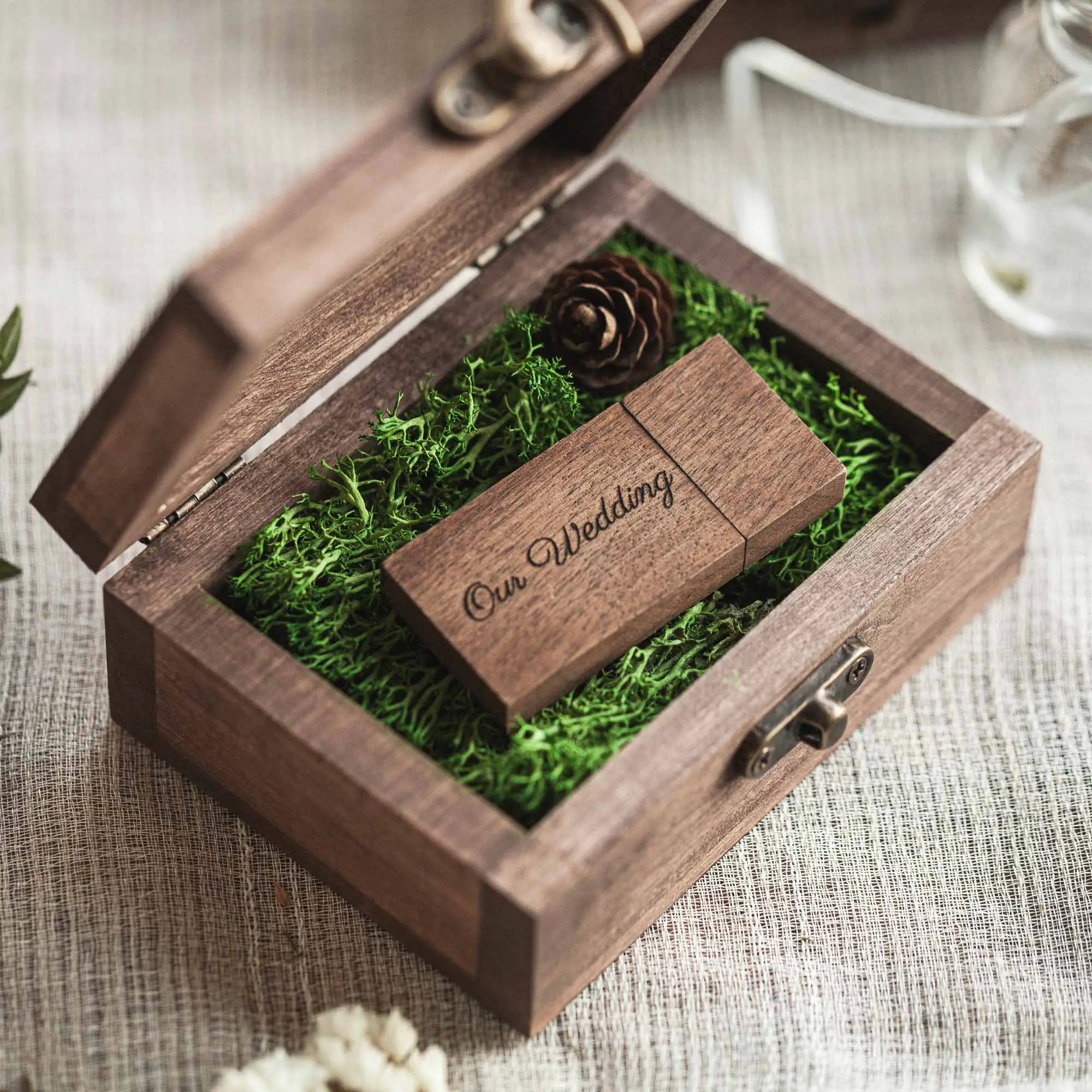 Partially opened wooden USB box revealing moss filler and wooden USB drive.