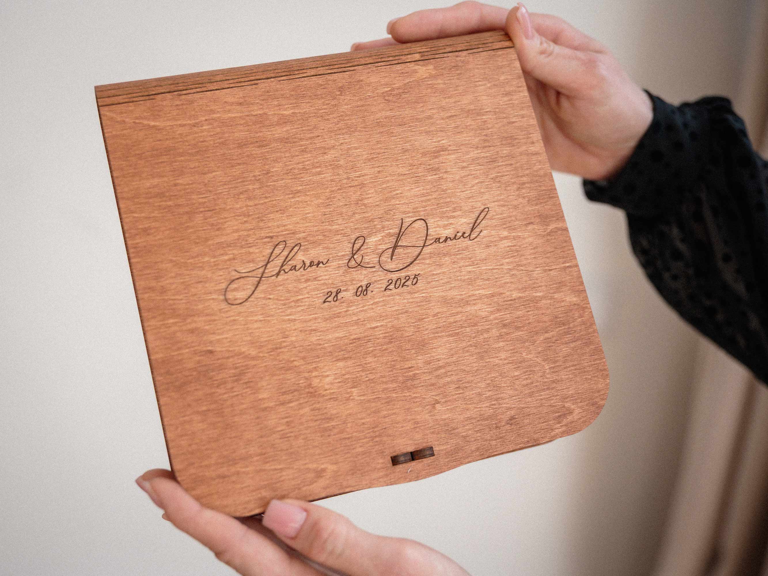 Teak wedding photo box with engraved names held in hands