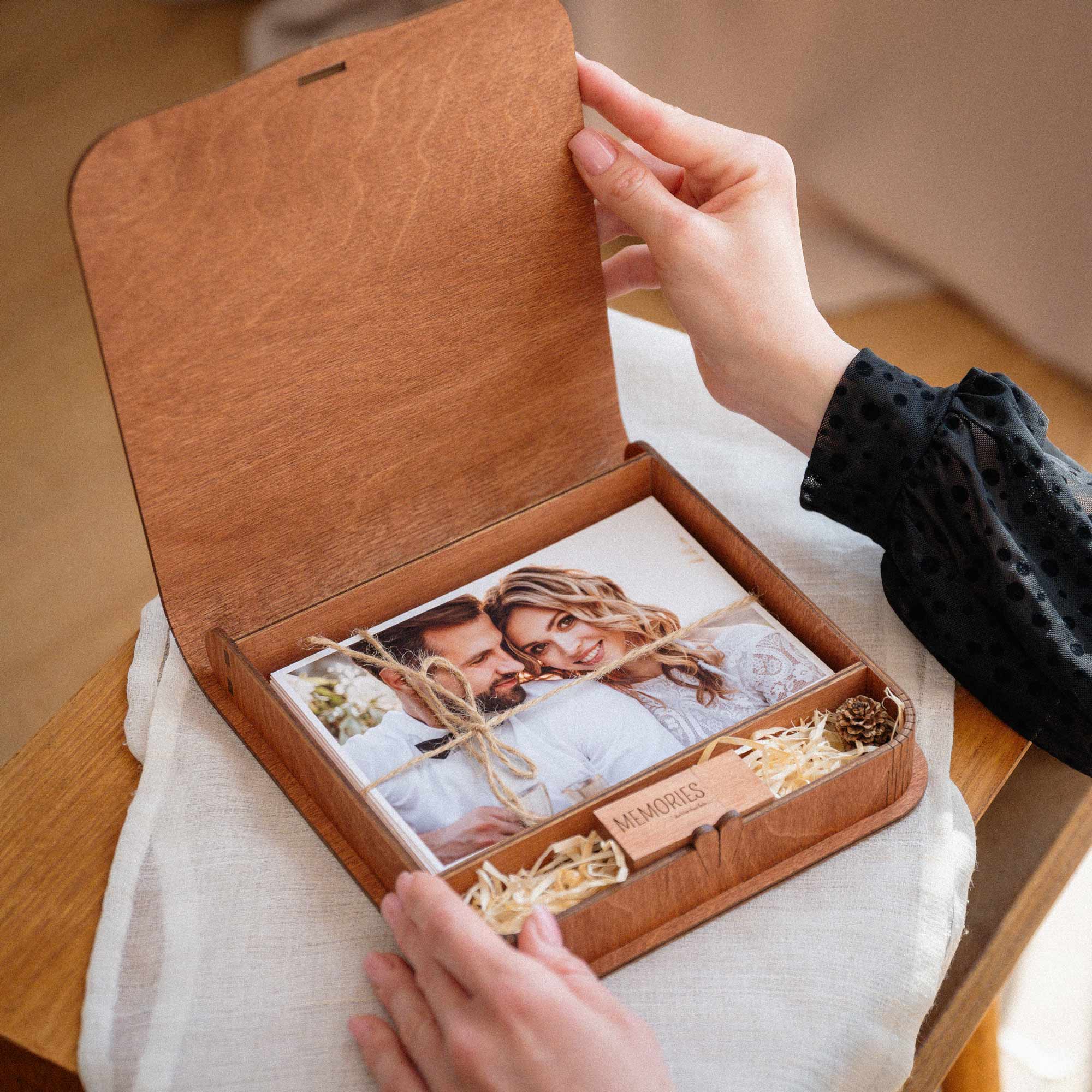 Opening teak wedding photo box with USB and printed wedding photos inside