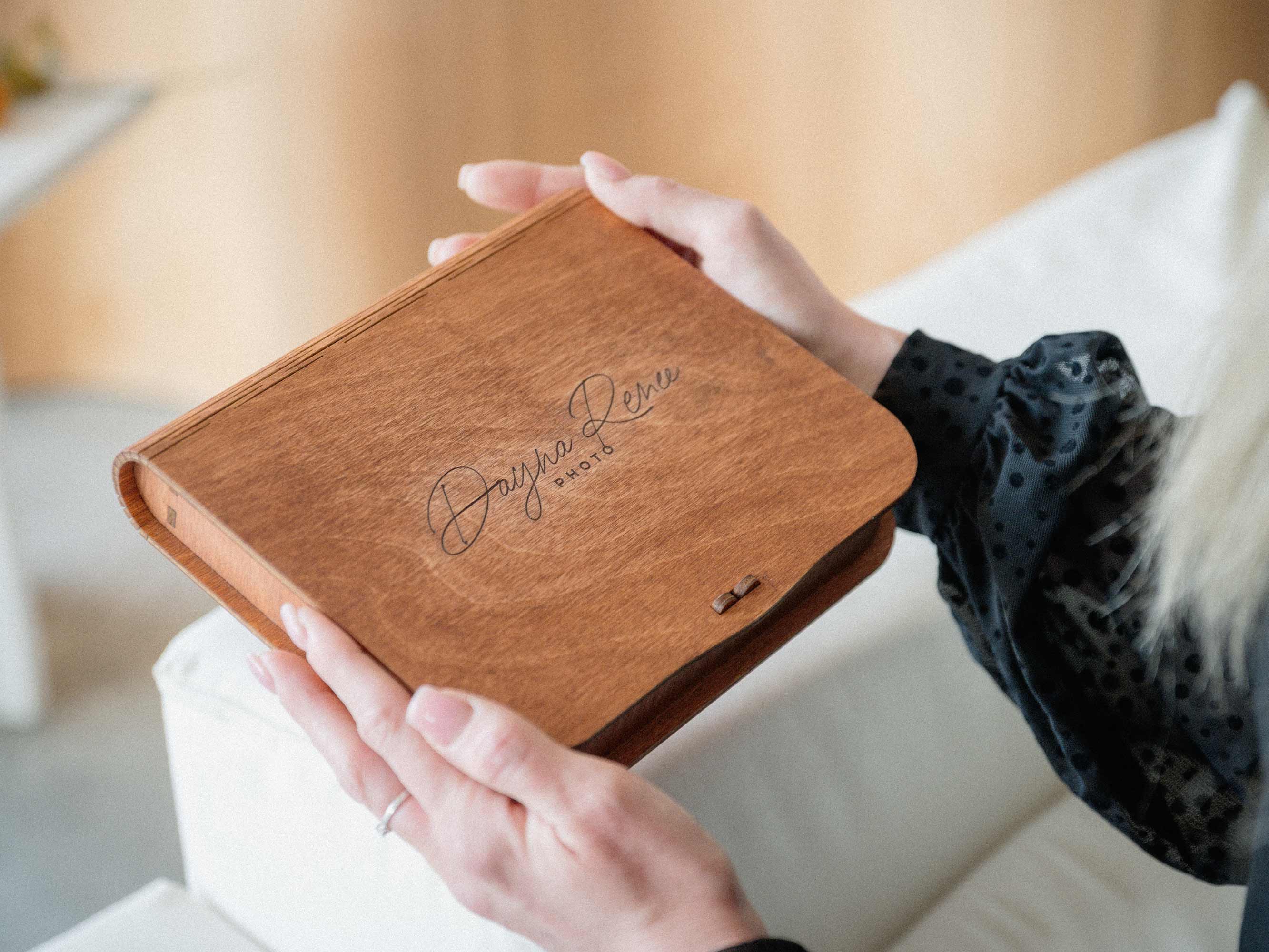 Teak wooden photo box with custom engraving held in hands