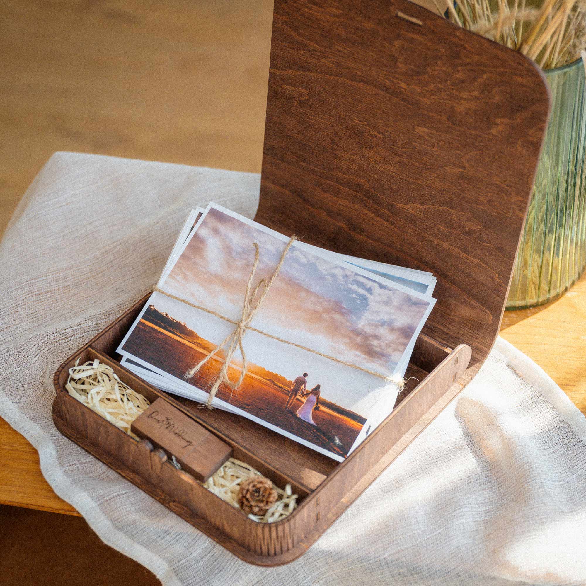 Open wooden photo box with USB compartment and wedding prints inside