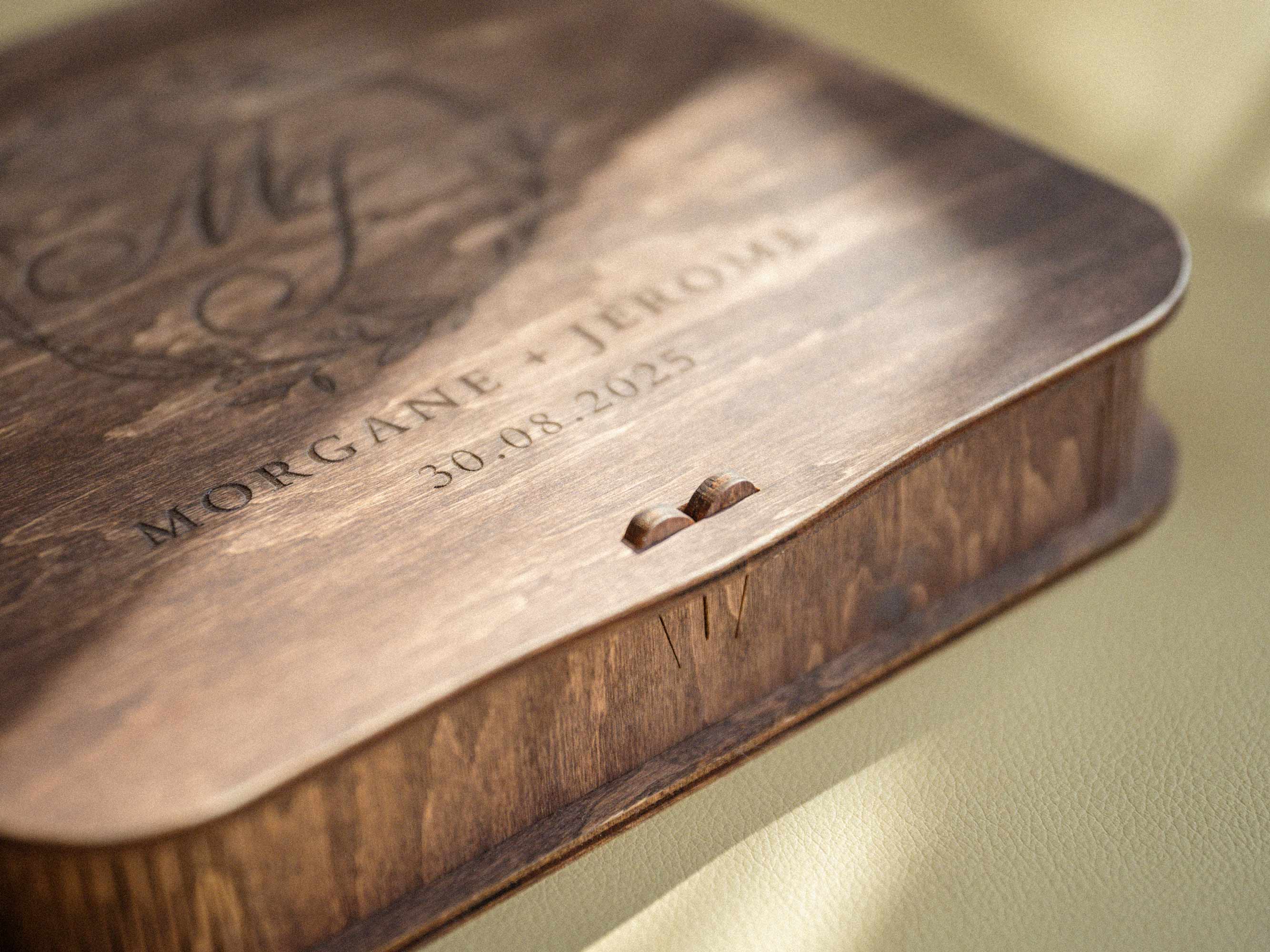 Close up of vintage style wooden photo box lid with engraved initials and names