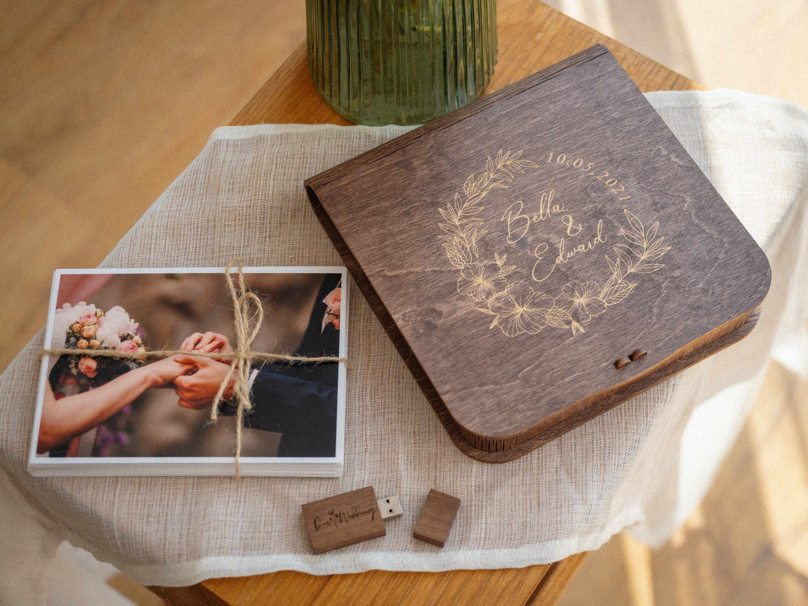 Walnut wooden photo box with light engraved floral design held in hands