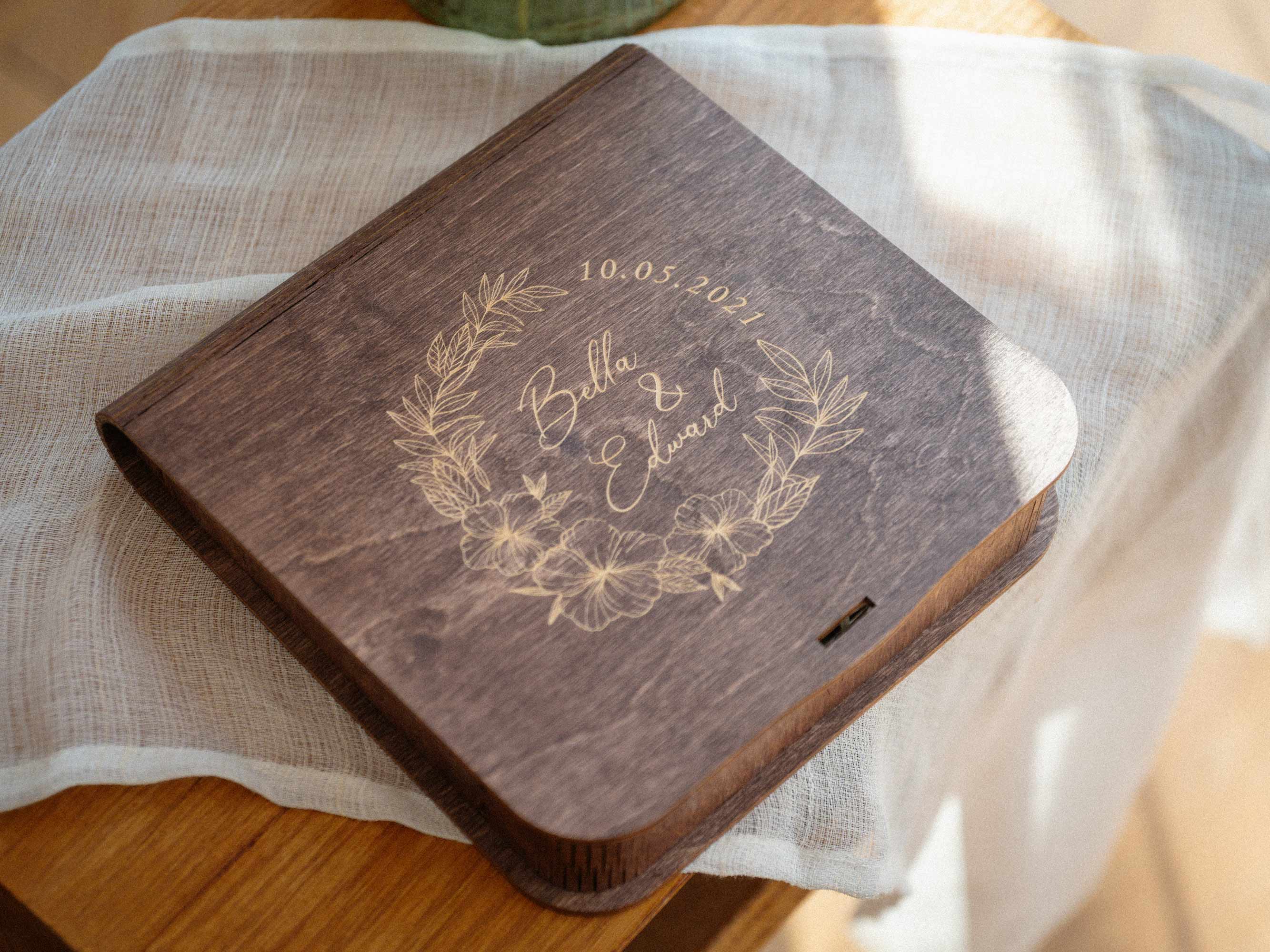 Closed walnut wooden photo box with personalized floral engraving on lid