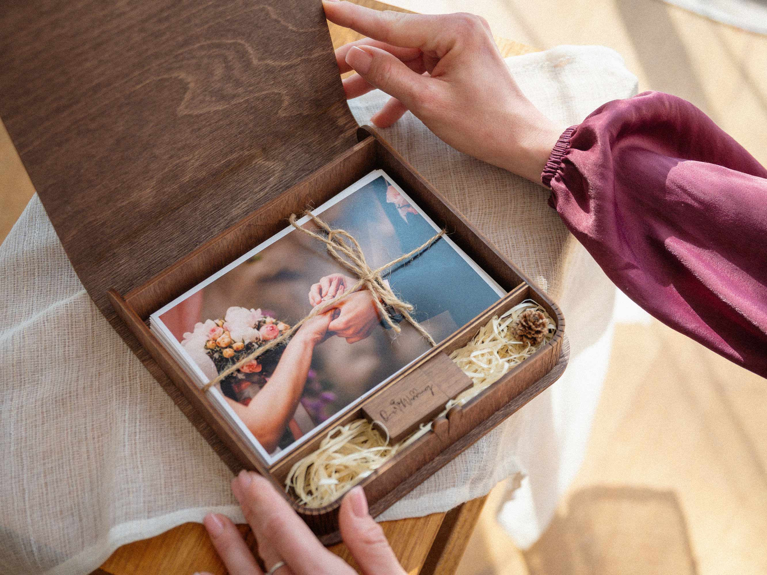 Open walnut wooden photo box with USB and wedding photo prints