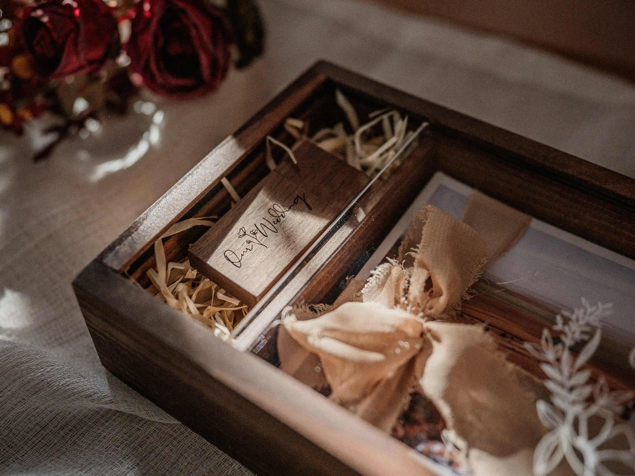 Open wooden photo box with USB compartment, photo print and wood shavings filler