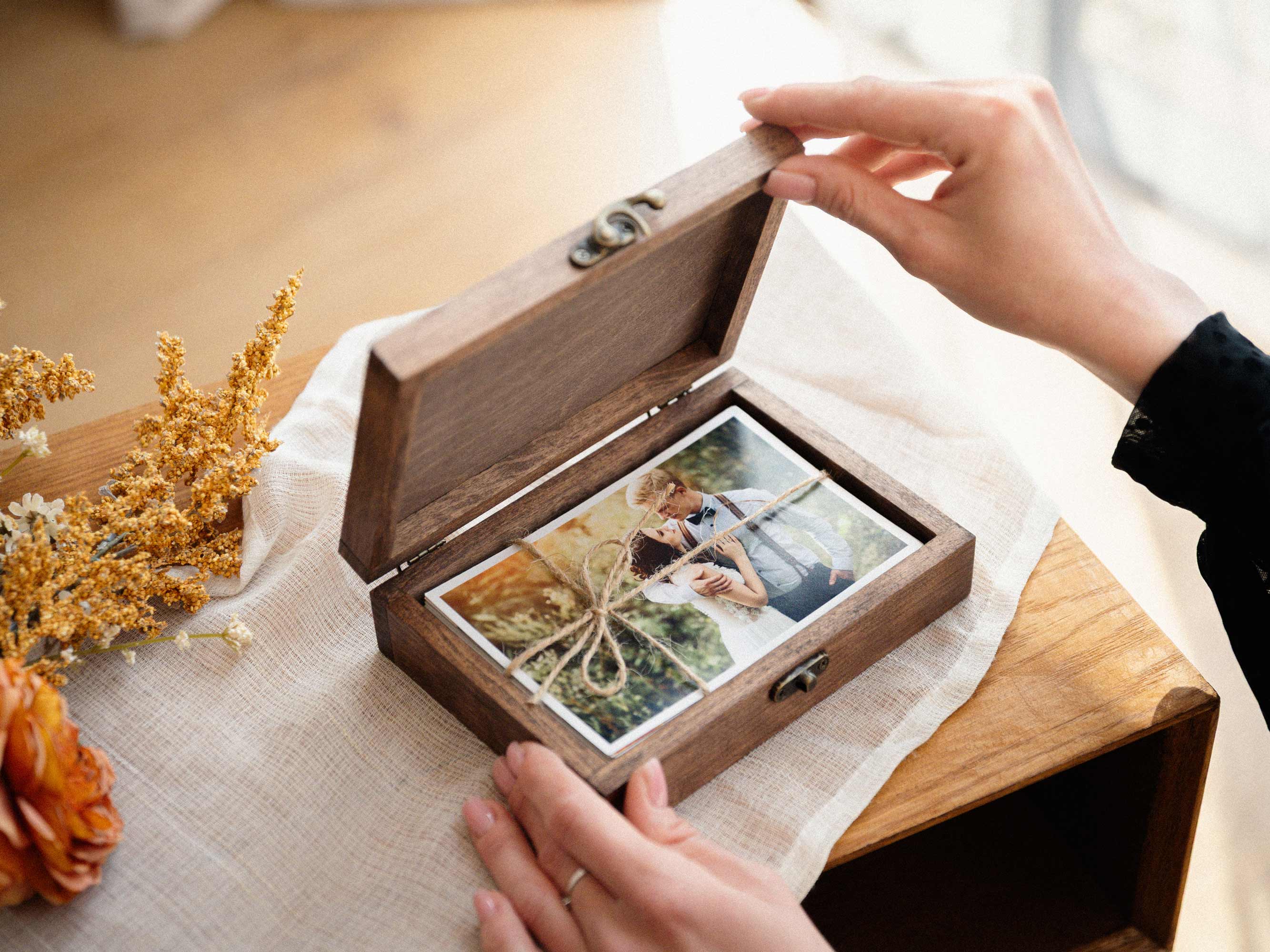 Walnut Classic hinged photo box being opened to reveal wedding prints