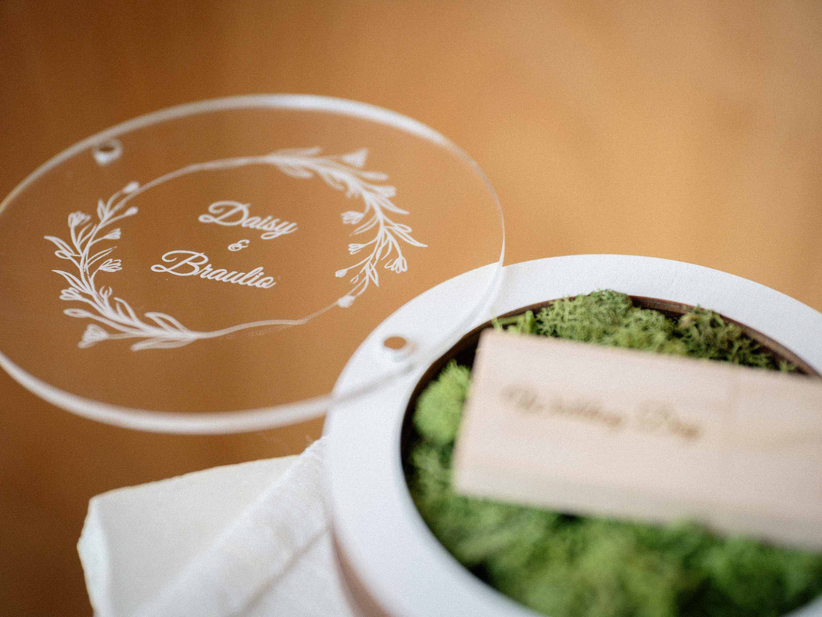 White USB box with personalized acrylic lid and light wooden flash drive on green moss