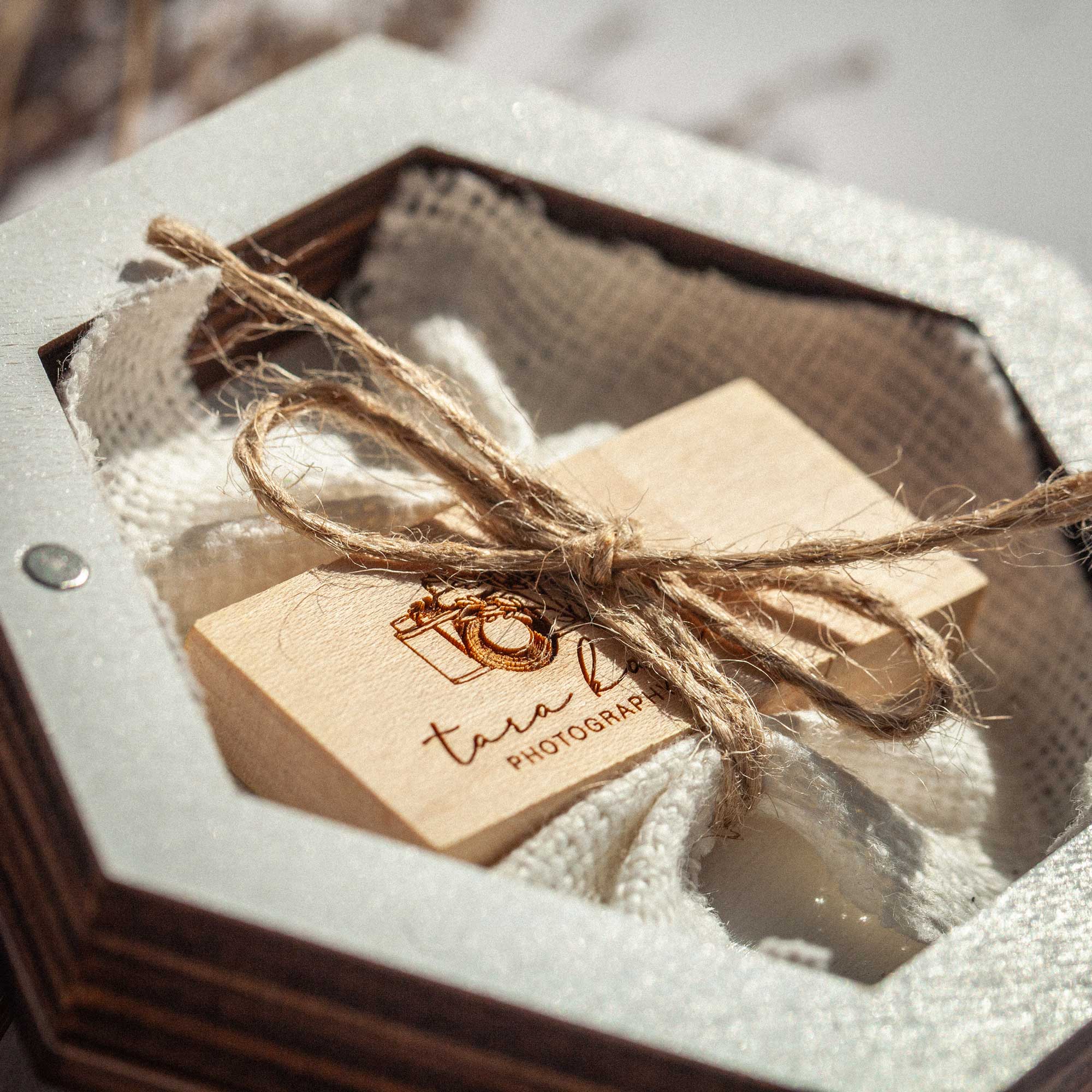 Close up of white wedding USB box with wooden flash drive and linen filling