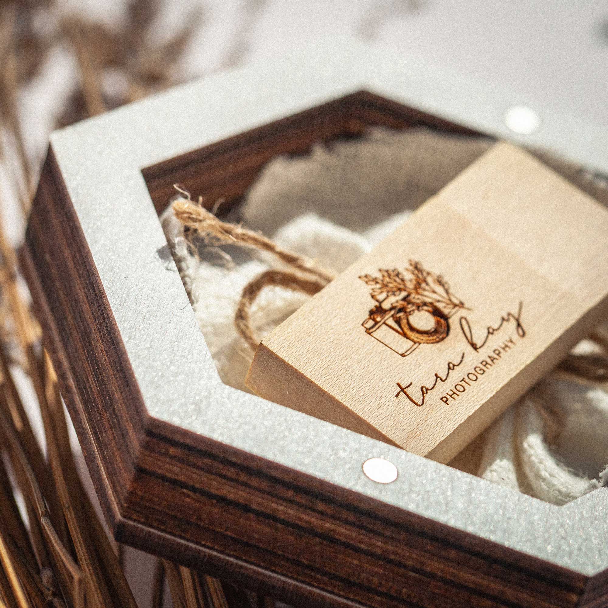Open white wedding USB box with wooden flash drive and natural flax filling