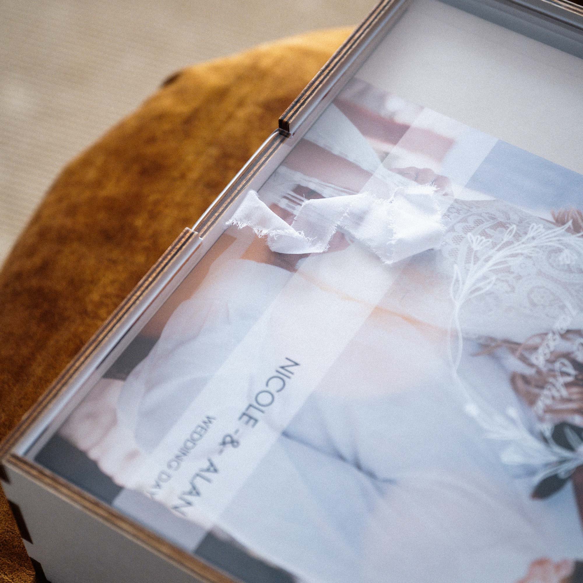 Close view of white photo album box with acrylic lid and wedding album inside