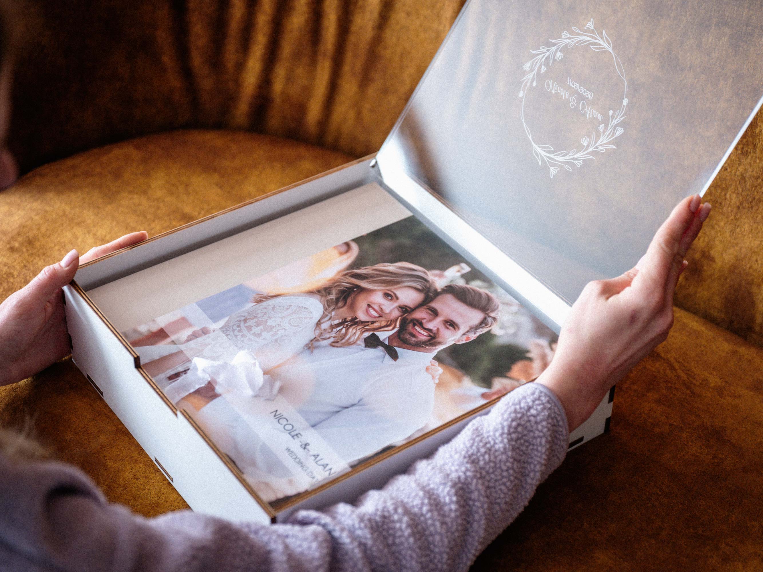 White wooden album box with clear lid opened by hands, elegant wedding presentation box