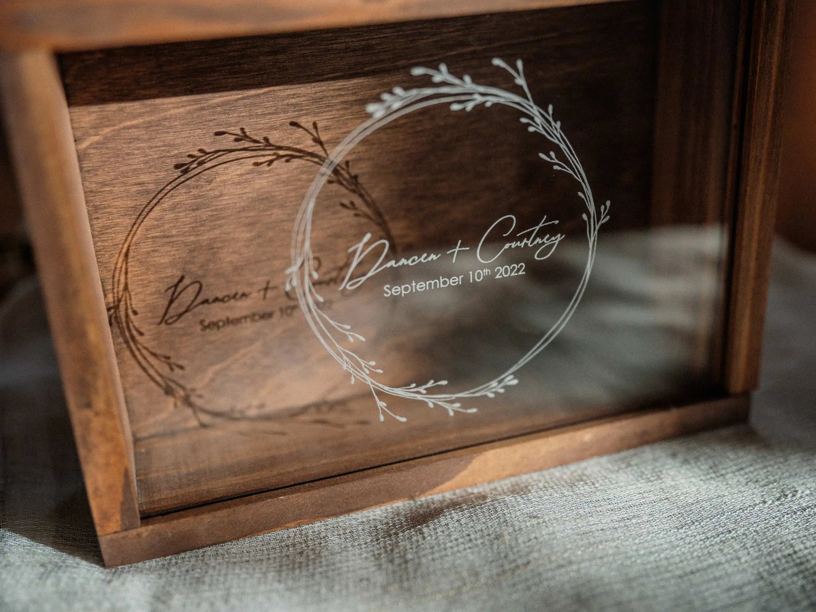 Close-up of personalized acrylic lid on walnut wooden photo box