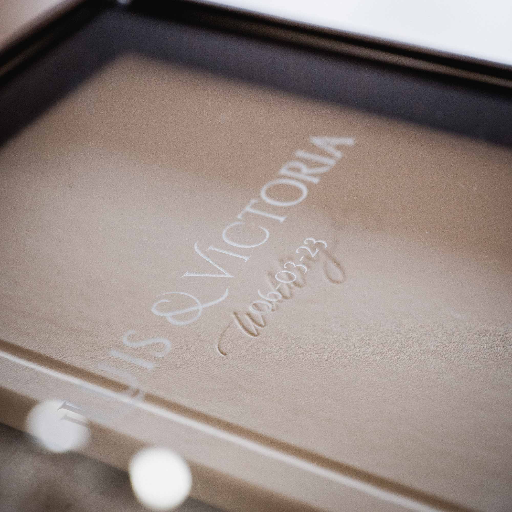 Detail of custom engraving on acrylic album box lid with soft bokeh lights